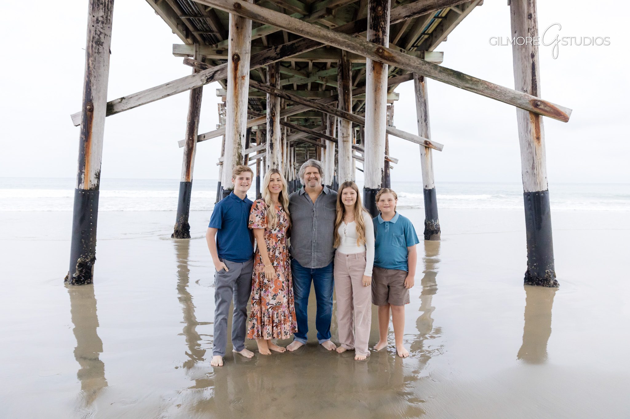 Newport Pier family mini session photographer capturing parents and children walking on the sand.

Sunset family portrait photography at Newport Beach Pier during mini session.