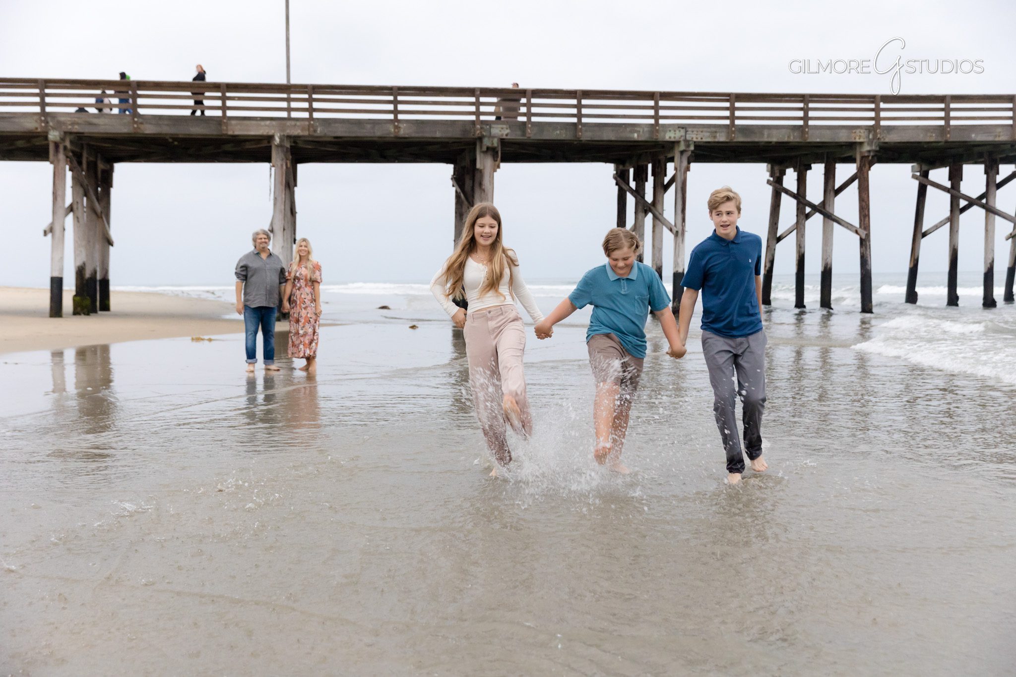 Newport Beach family photography with neutral outfits at sunset.

Walking shot portrait photography along Newport Pier shoreline.