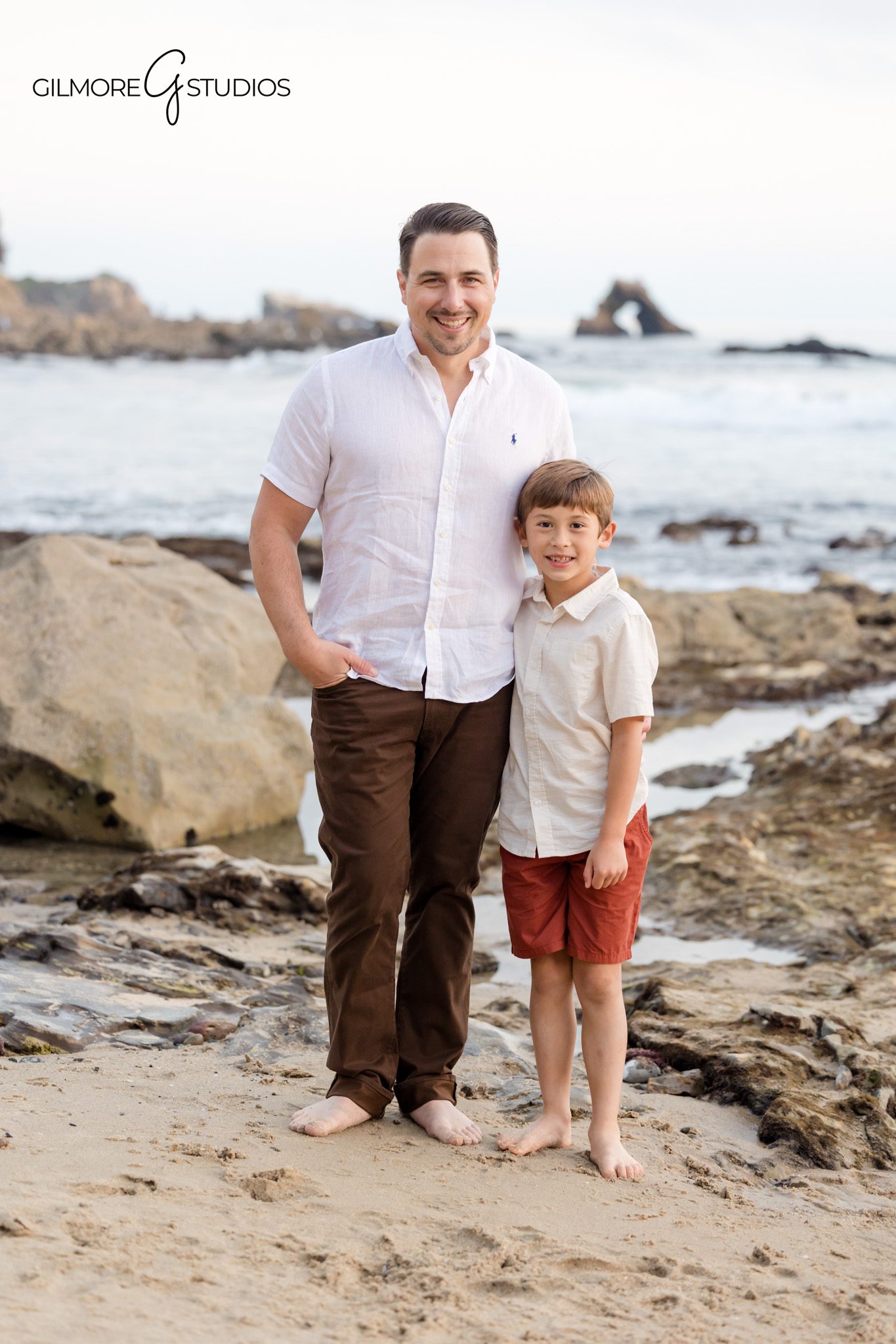 Family portrait photography with rocky coastline backdrop in Newport Beach.

Little Corona Beach photographer capturing barefoot family walking by the ocean.