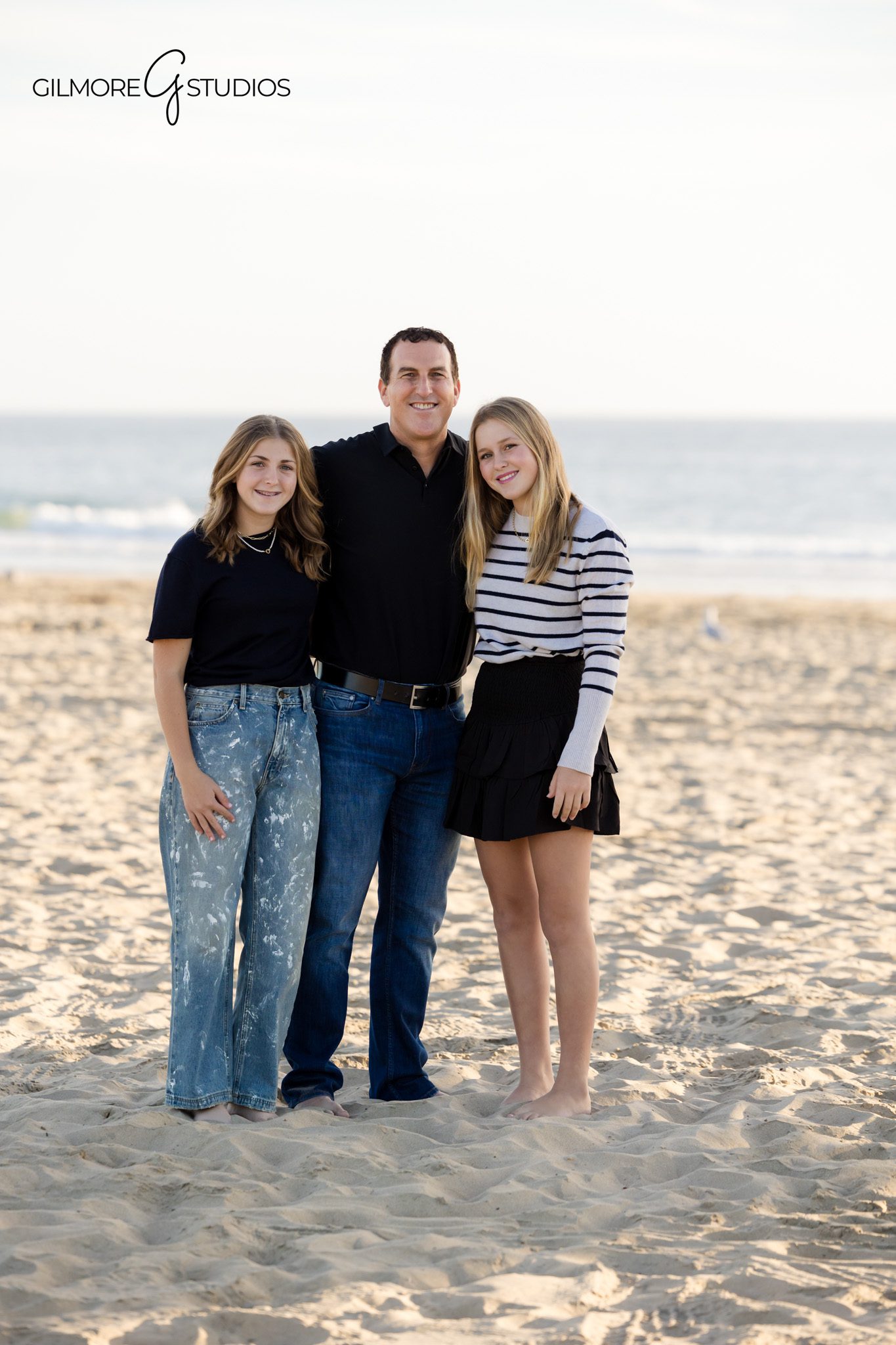 Teen girls beach family session photographed by a professional photographer
Newport Beach family photography session with teens walking near the pier
