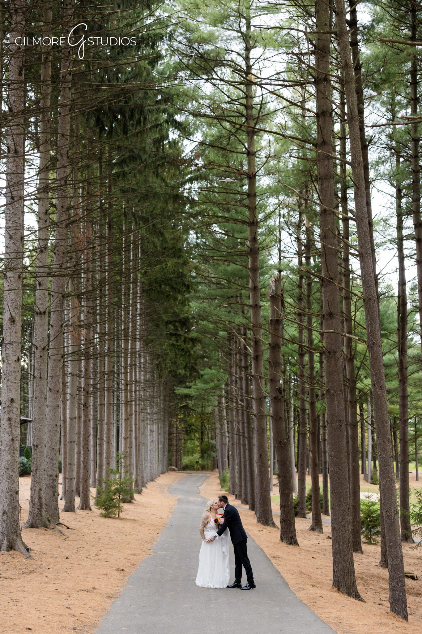 Bride twirling in wedding dress photographed in forest setting.

Photographer capturing couple walking hand in hand.