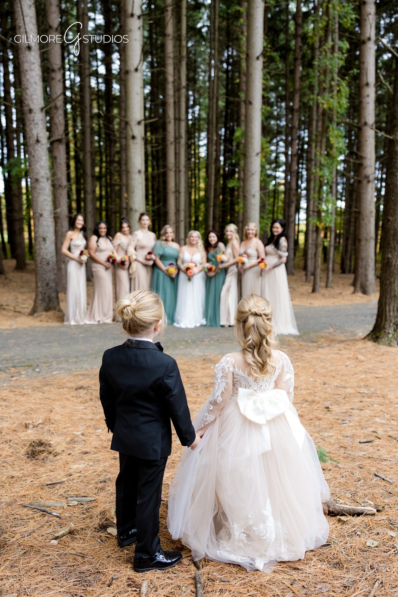 Wedding photography focusing on rings and floral details.

Bride and groom portrait photography against dark pine silhouettes.