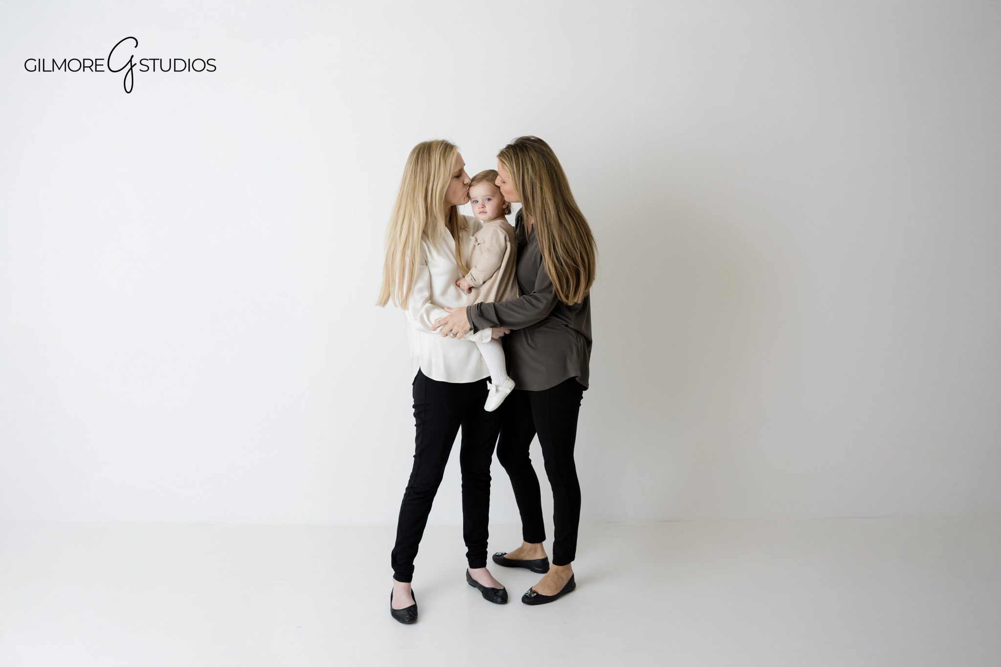 Family photographer documenting siblings sitting on white backdrop.

Clean studio photography with family dressed in neutral outfits.