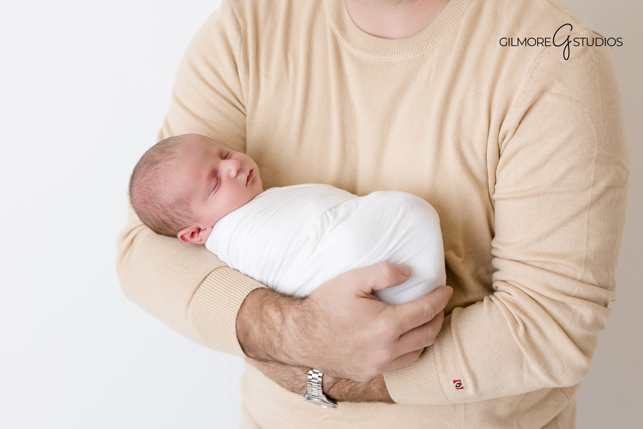 Arizona baby photographer capturing classic newborn swaddle pose.

Newborn portrait photography with baby on cream blanket.