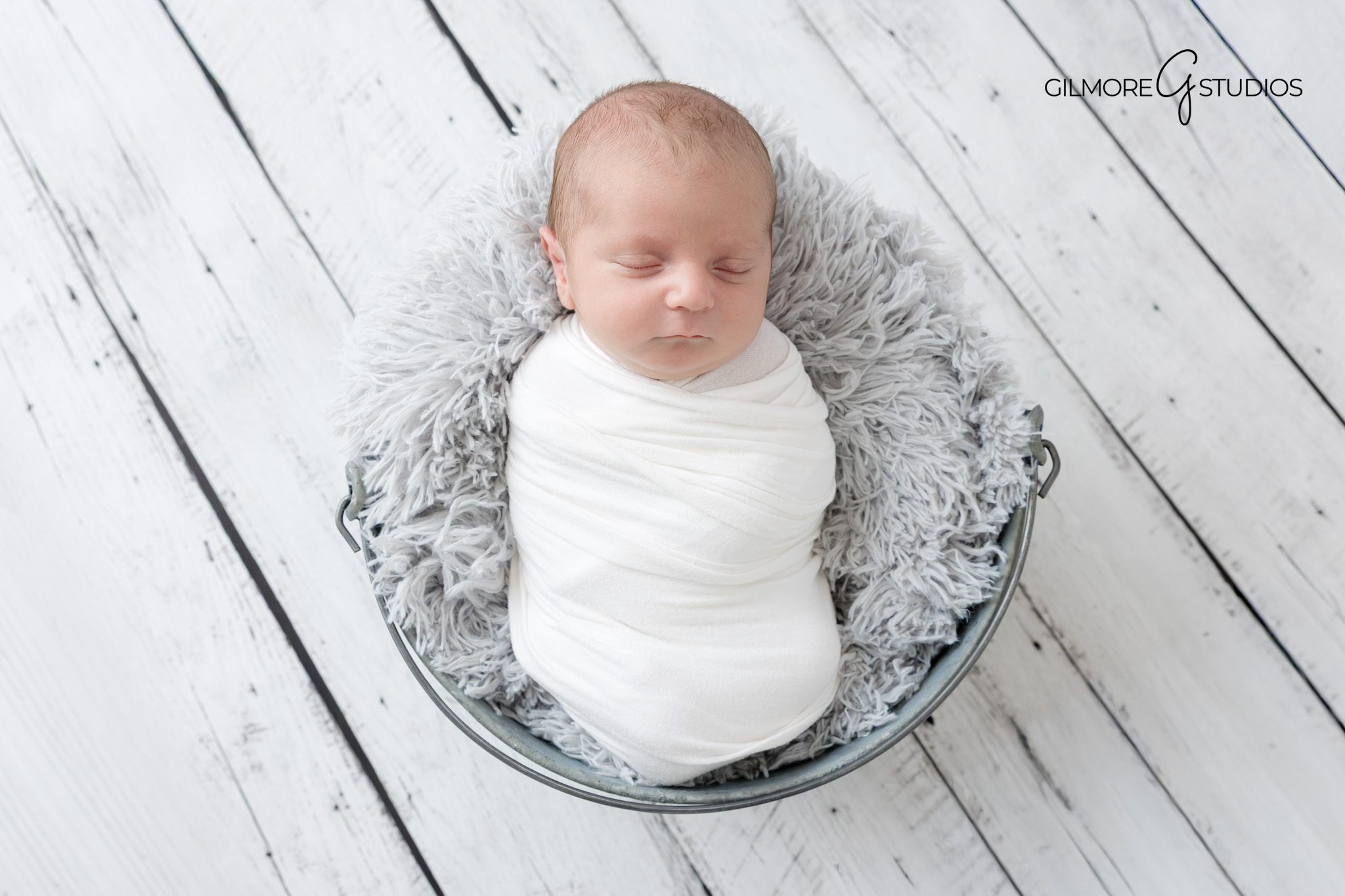 Newborn photographer in Gilbert AZ capturing soft swaddled baby portrait.

Gilbert AZ newborn photography session with neutral studio setup.