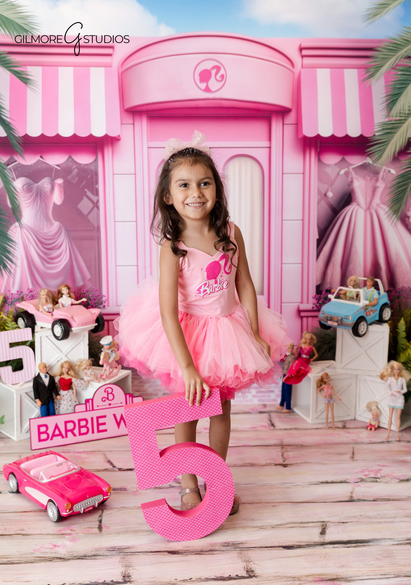 Professional birthday photographer capturing Barbie themed child portrait

5th birthday portrait photography with pink backdrop and fun expressions