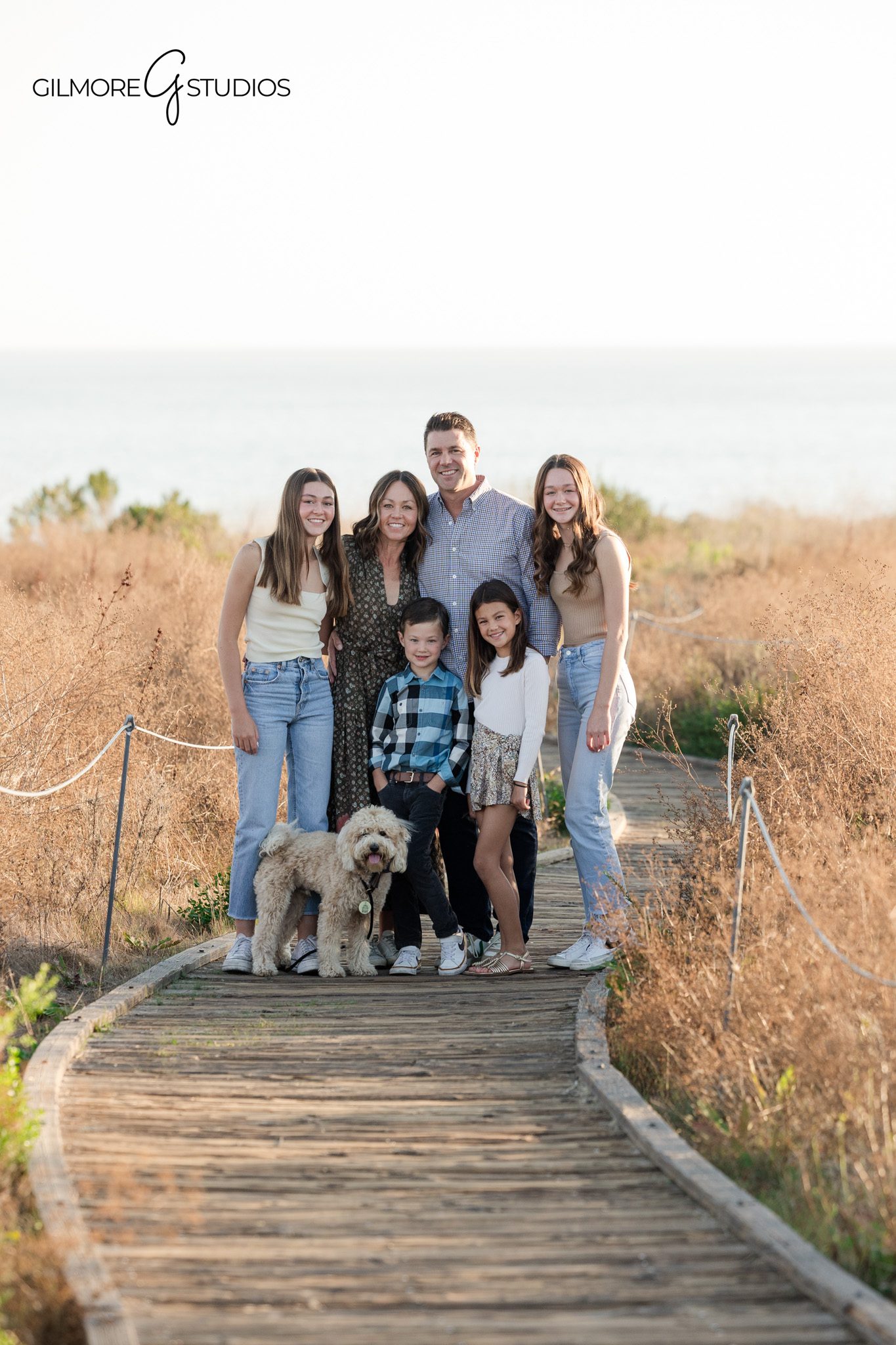 newport beach family portrait on coastal trail with ocean background photography
crystal cove family photos california with warm golden light and natural posing