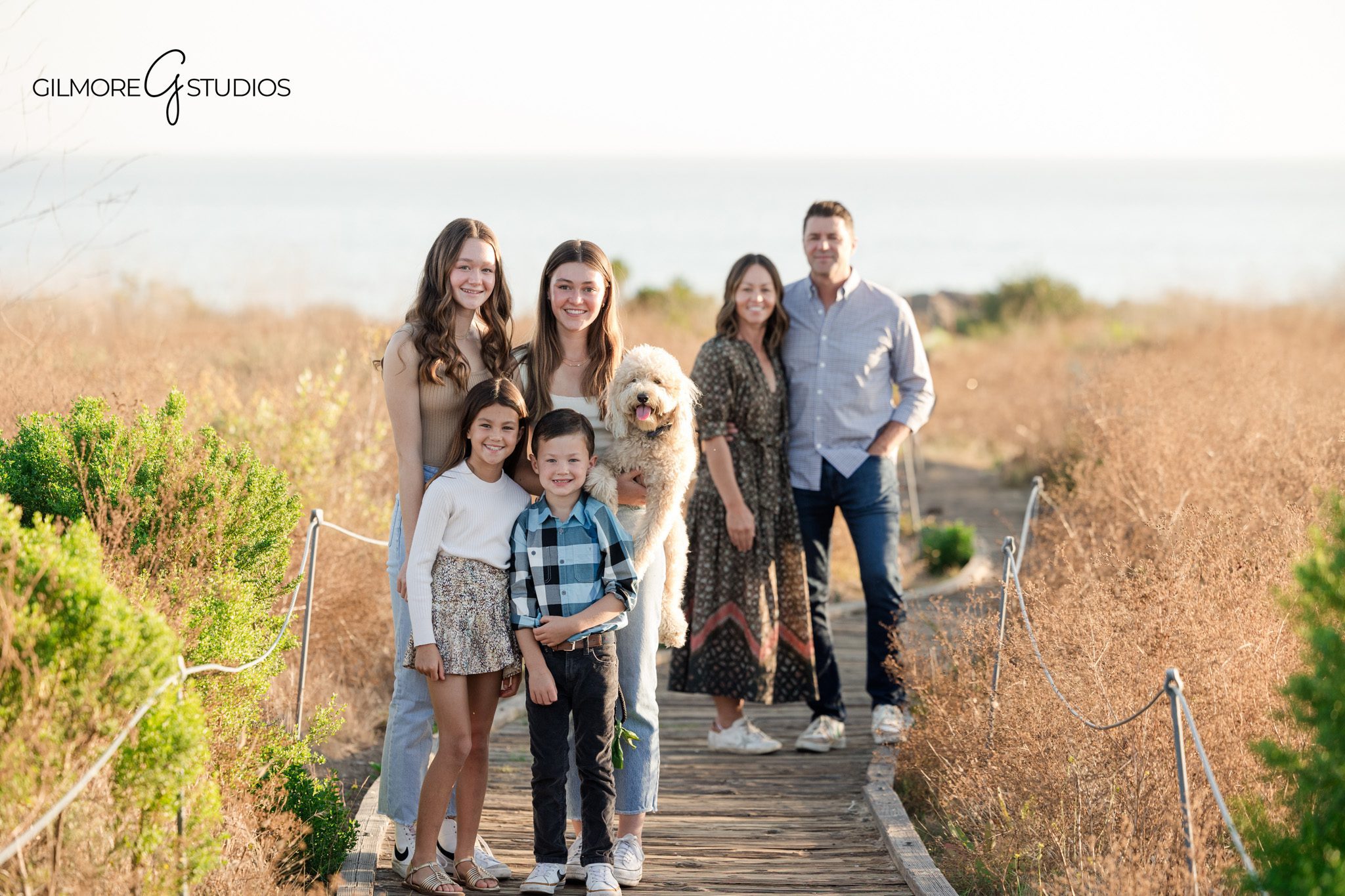 orange county family photographer capturing connection and movement outdoors
family portrait session crystal cove state park with neutral outfits styling