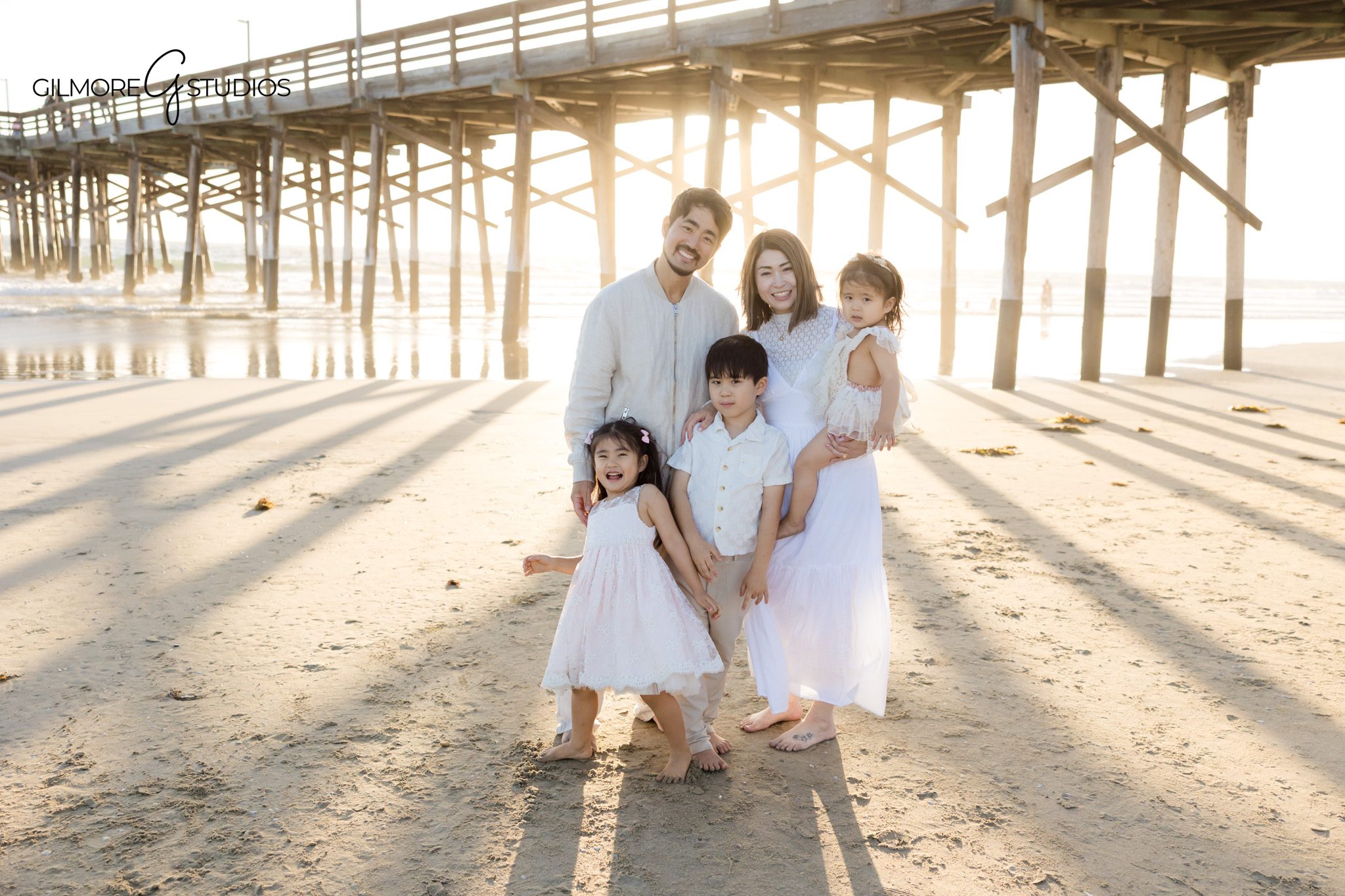 Family walking on beach near Newport Pier morning
Candid family moment beach session orange county