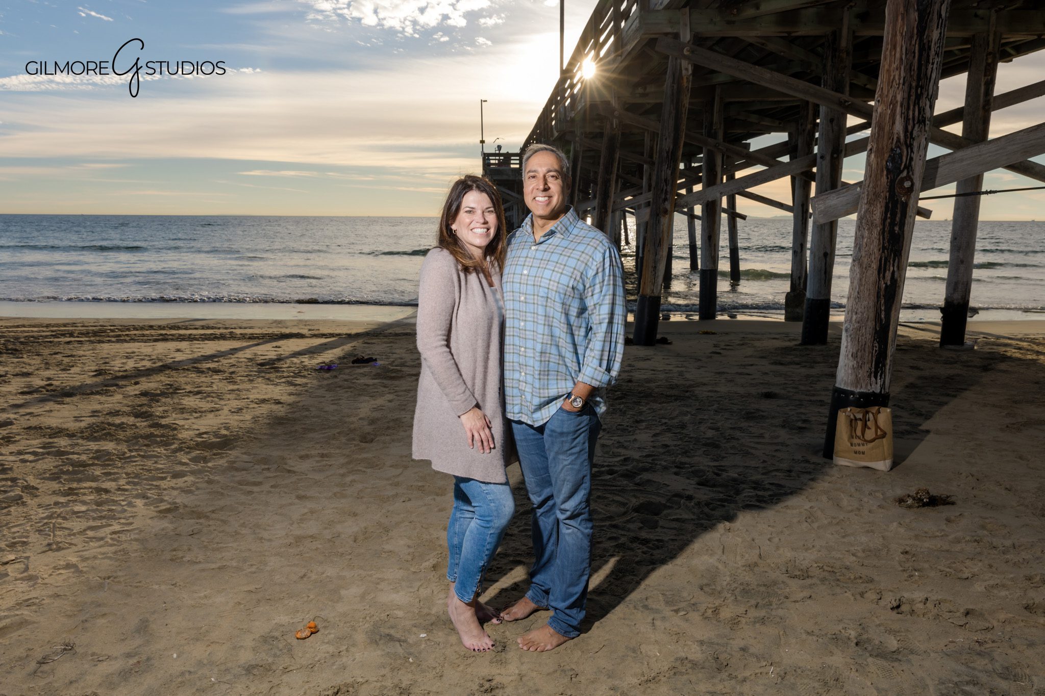 Newport Pier family photographer posing family under wooden beams
Newport Beach family portraits under pier depth and texture