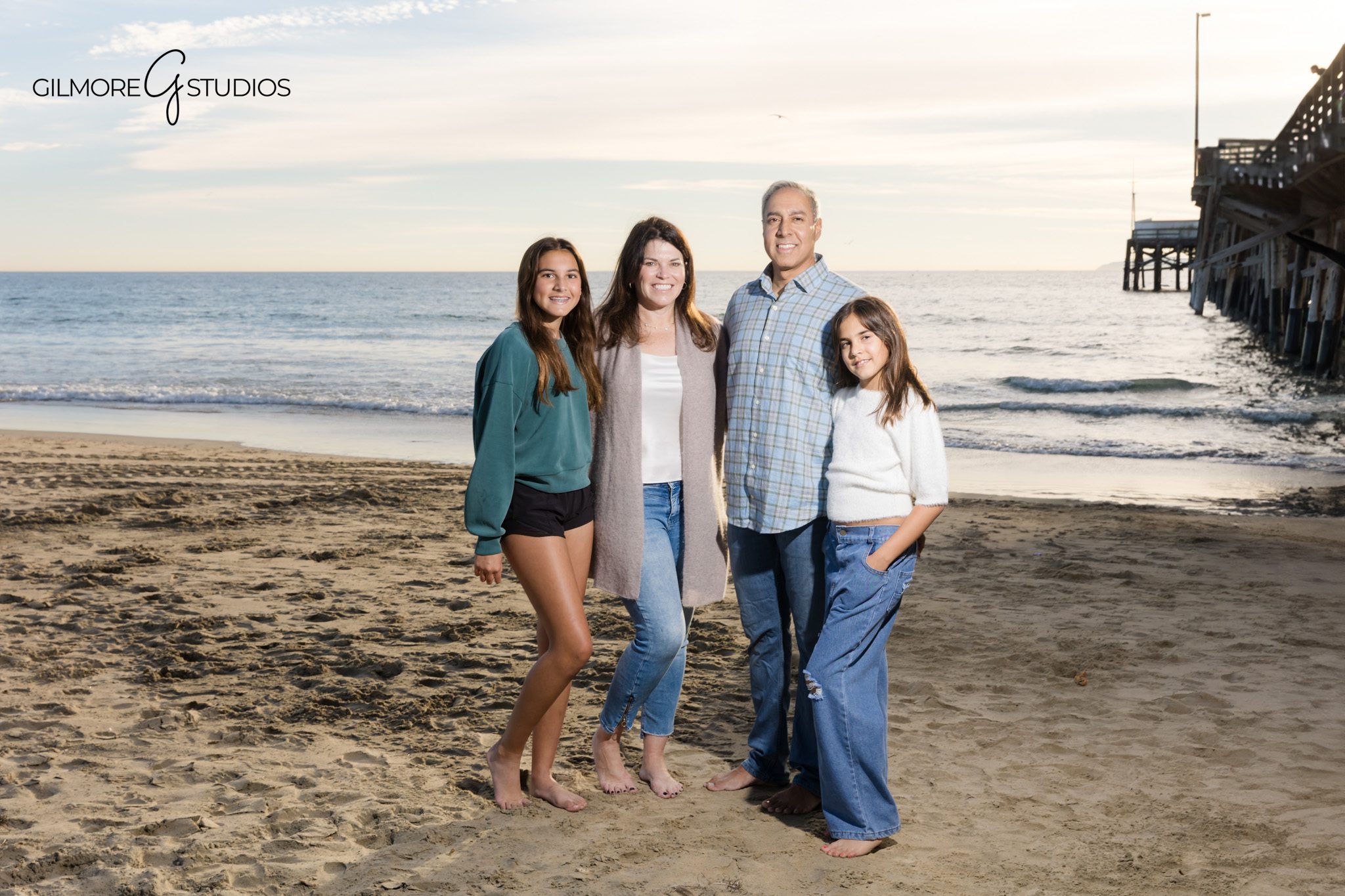 Newport Pier family photographer capturing family holding hands beach session
Newport Beach family photography natural connection moments ocean background