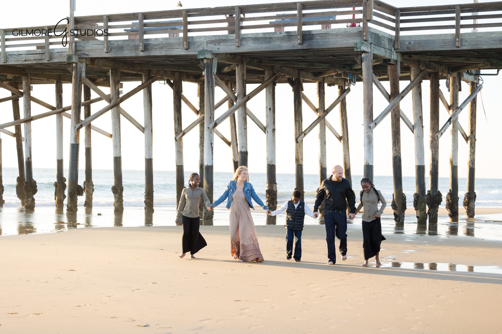 beach family photos Newport Beach family holding hands shoreline
lifestyle family photography Newport Pier connection moment