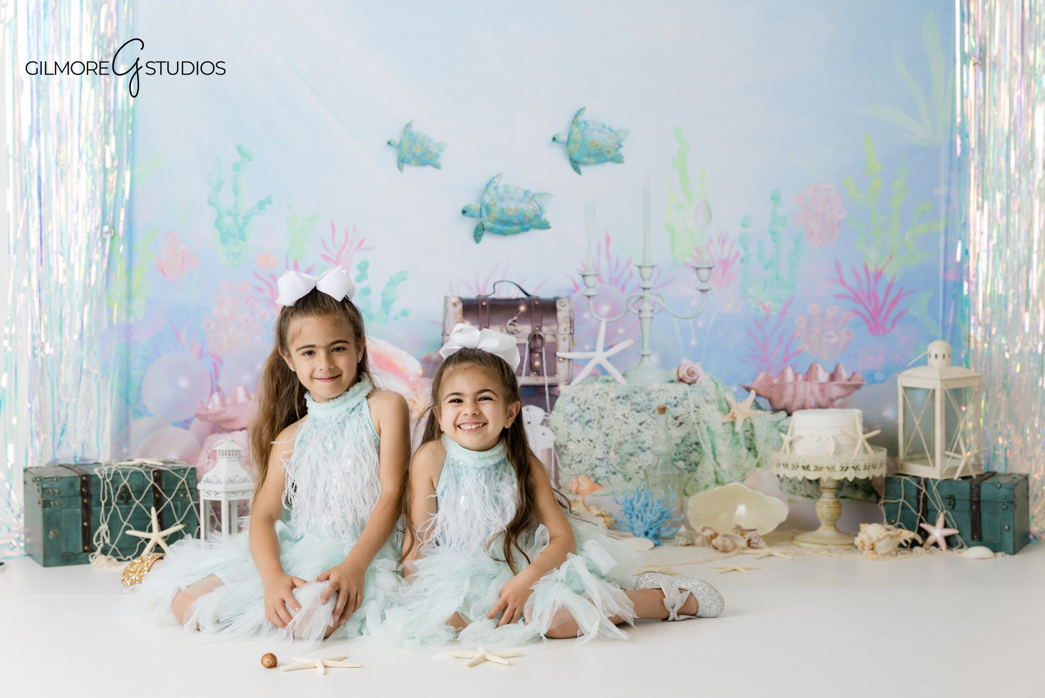 Mermaid inspired birthday photography Gilbert AZ, sisters sitting together in aqua dresses