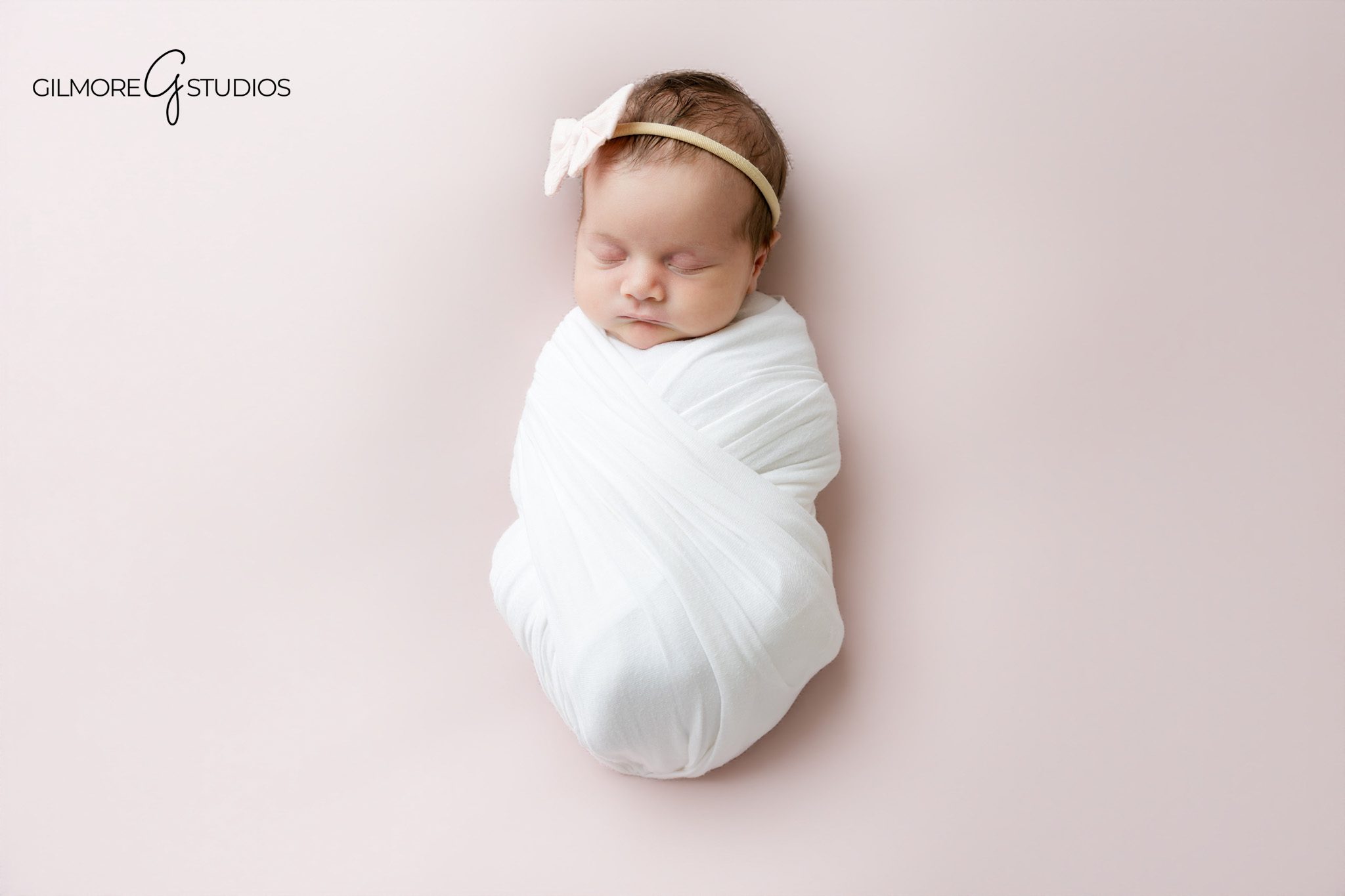 Baby girl studio newborn photography session with soft pink floral styling in Arizona