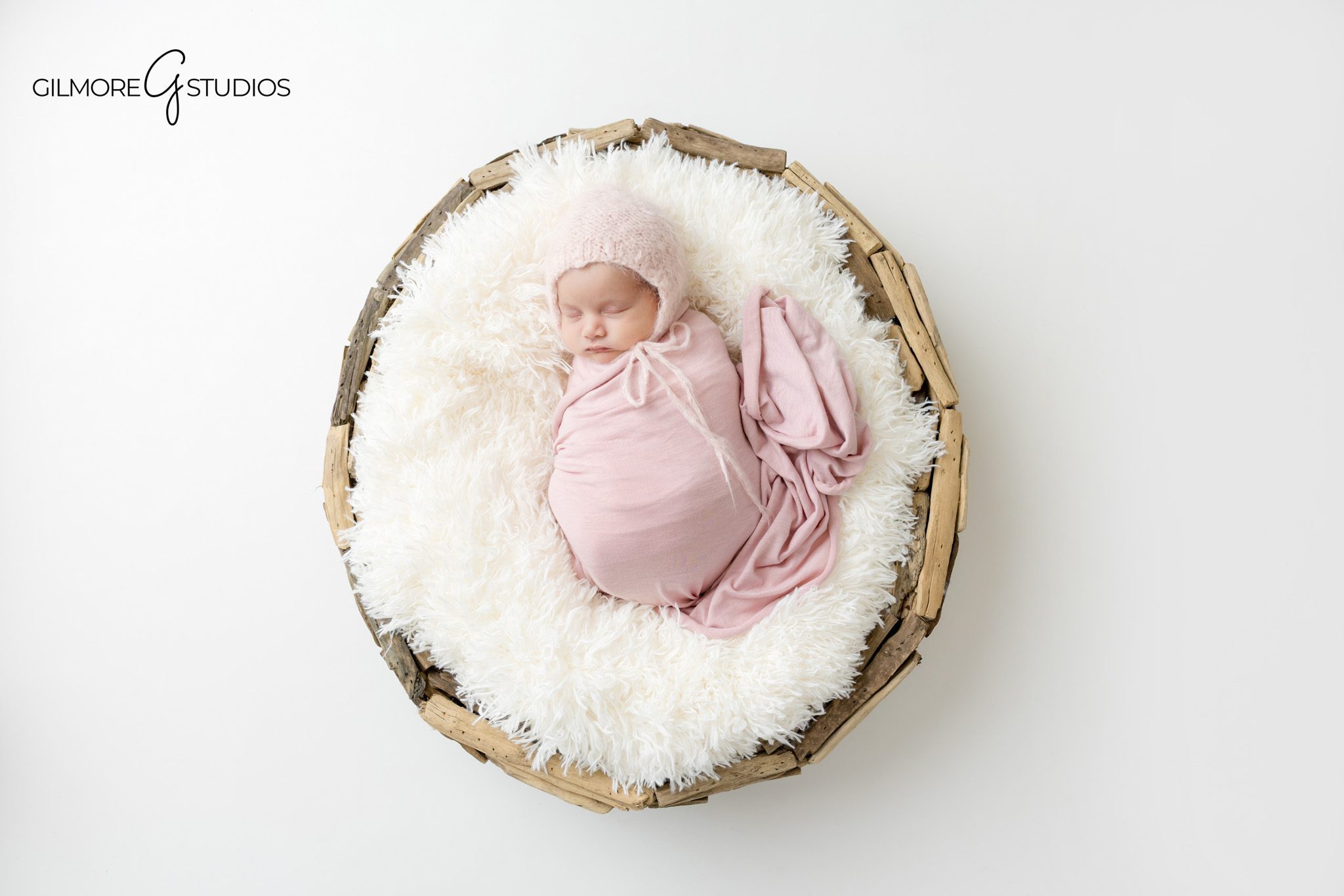 Gilbert AZ newborn studio photographer portrait of sleeping baby girl wrapped in white swaddle on soft pink backdrop
Baby girl newborn photography session in Gilbert Arizona with neutral white wrap and blush bow headband