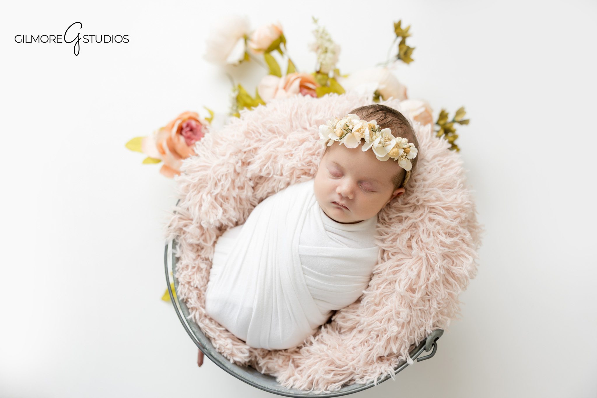 Baby girl newborn photography Gilbert AZ with soft pink bucket setup and neutral styling