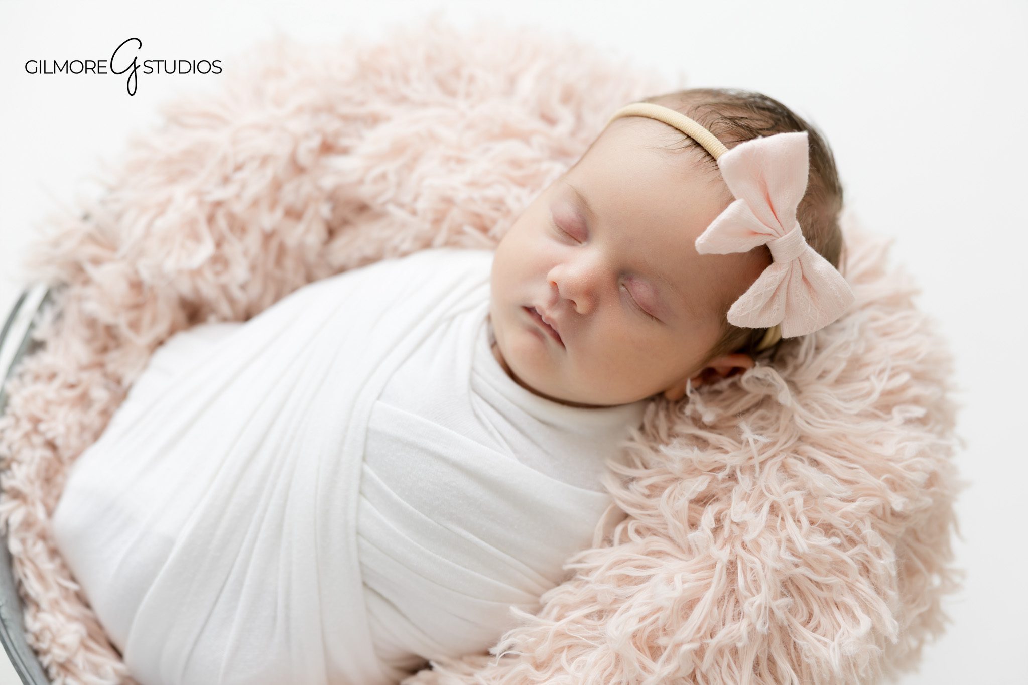 Professional newborn photographer Gilbert AZ featuring baby girl wrapped in soft white fabric