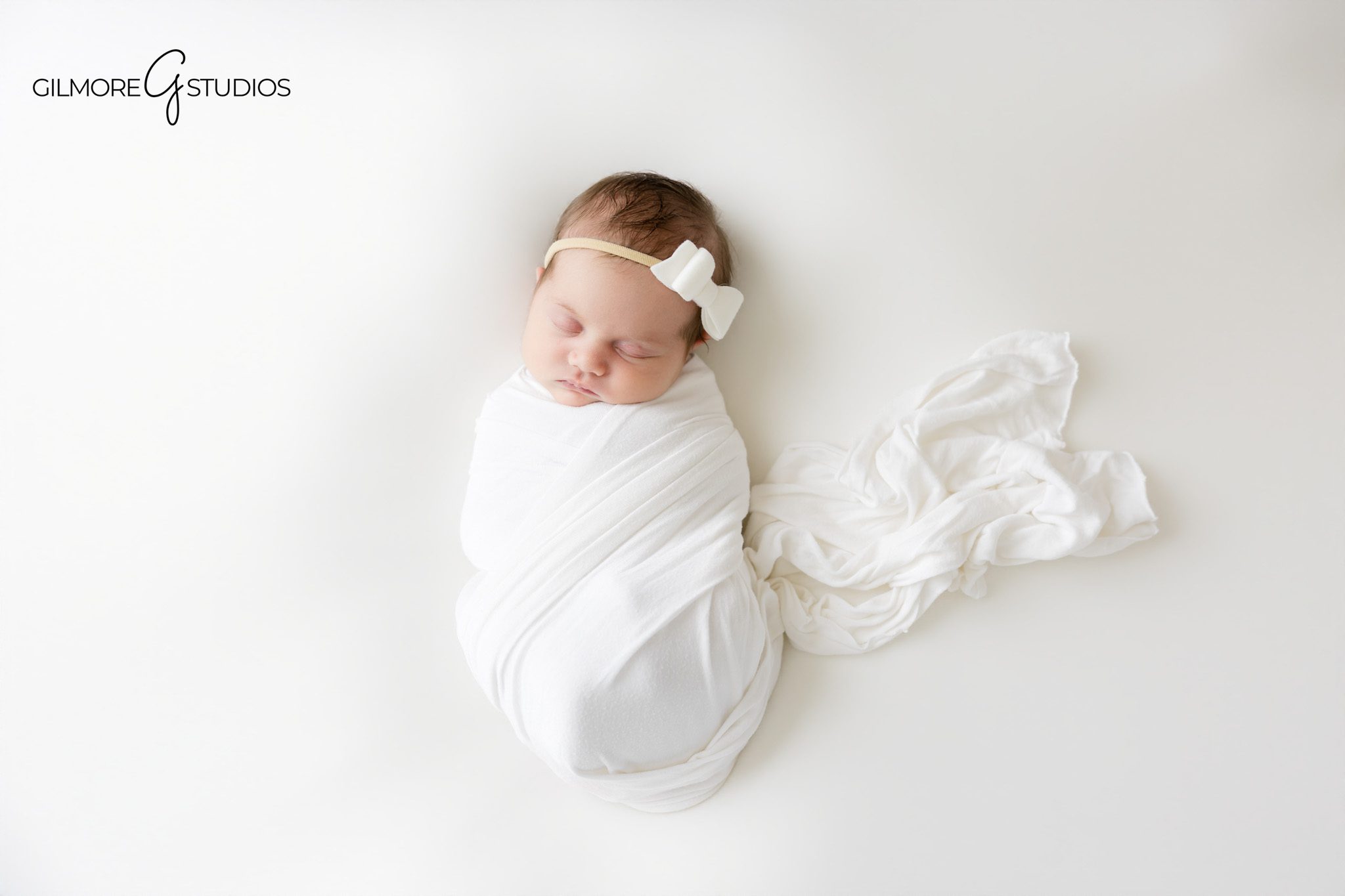 Posed newborn photographer Arizona featuring sleeping infant girl in fluffy blush prop