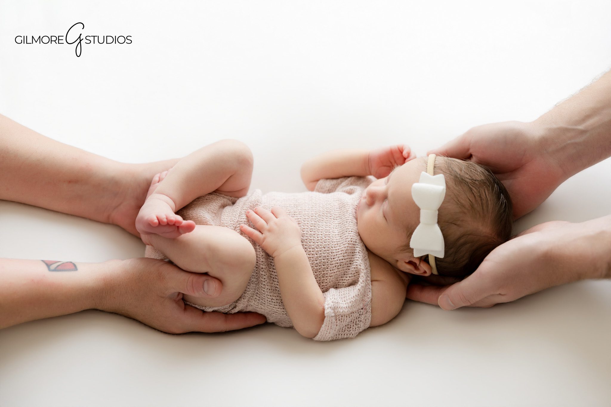 Gilbert AZ posed newborn session featuring baby girl wrapped in white swaddle inside wooden basket