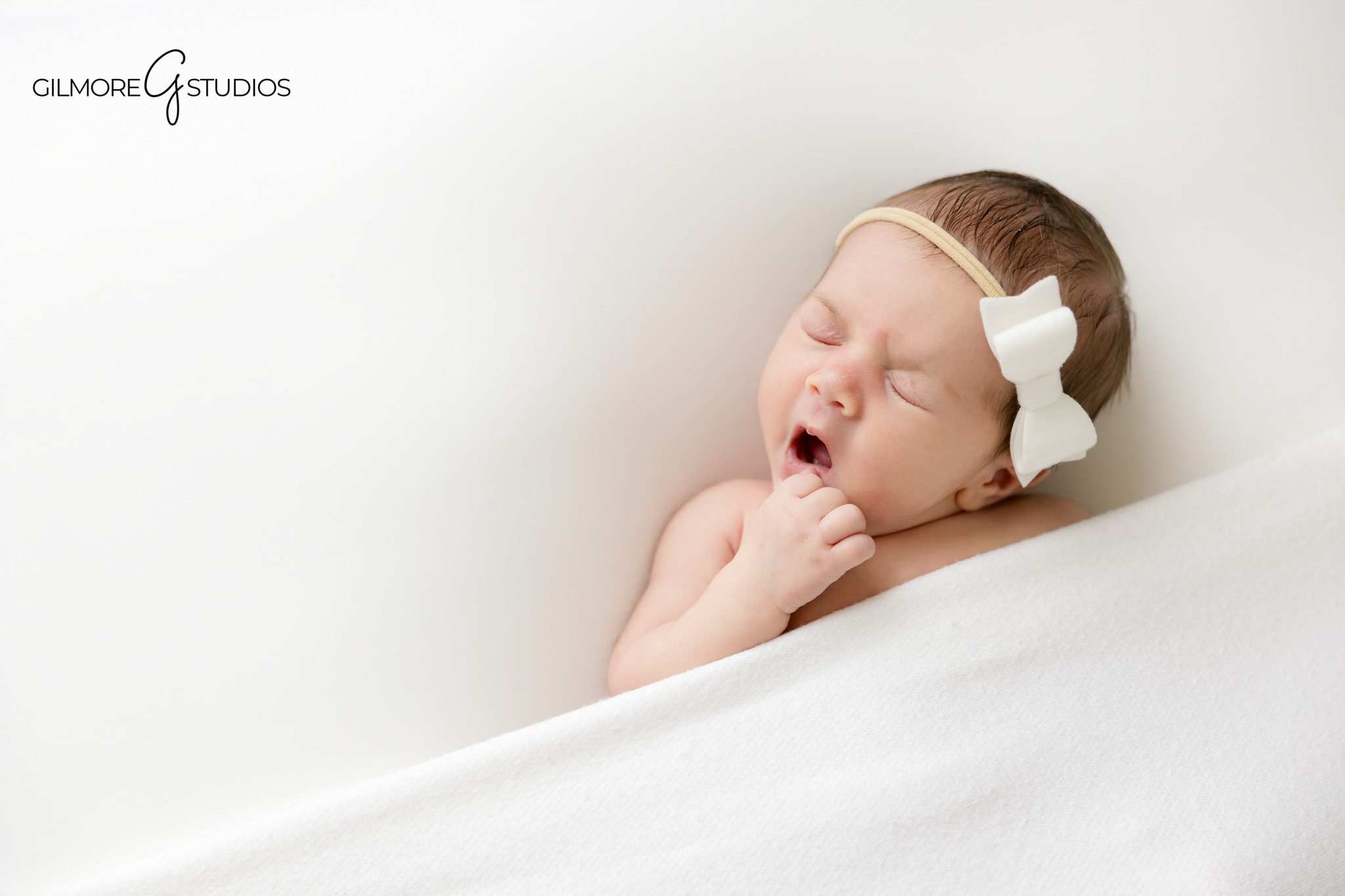 Newborn studio photography Gilbert Arizona with sleeping baby girl and cream textured blanket