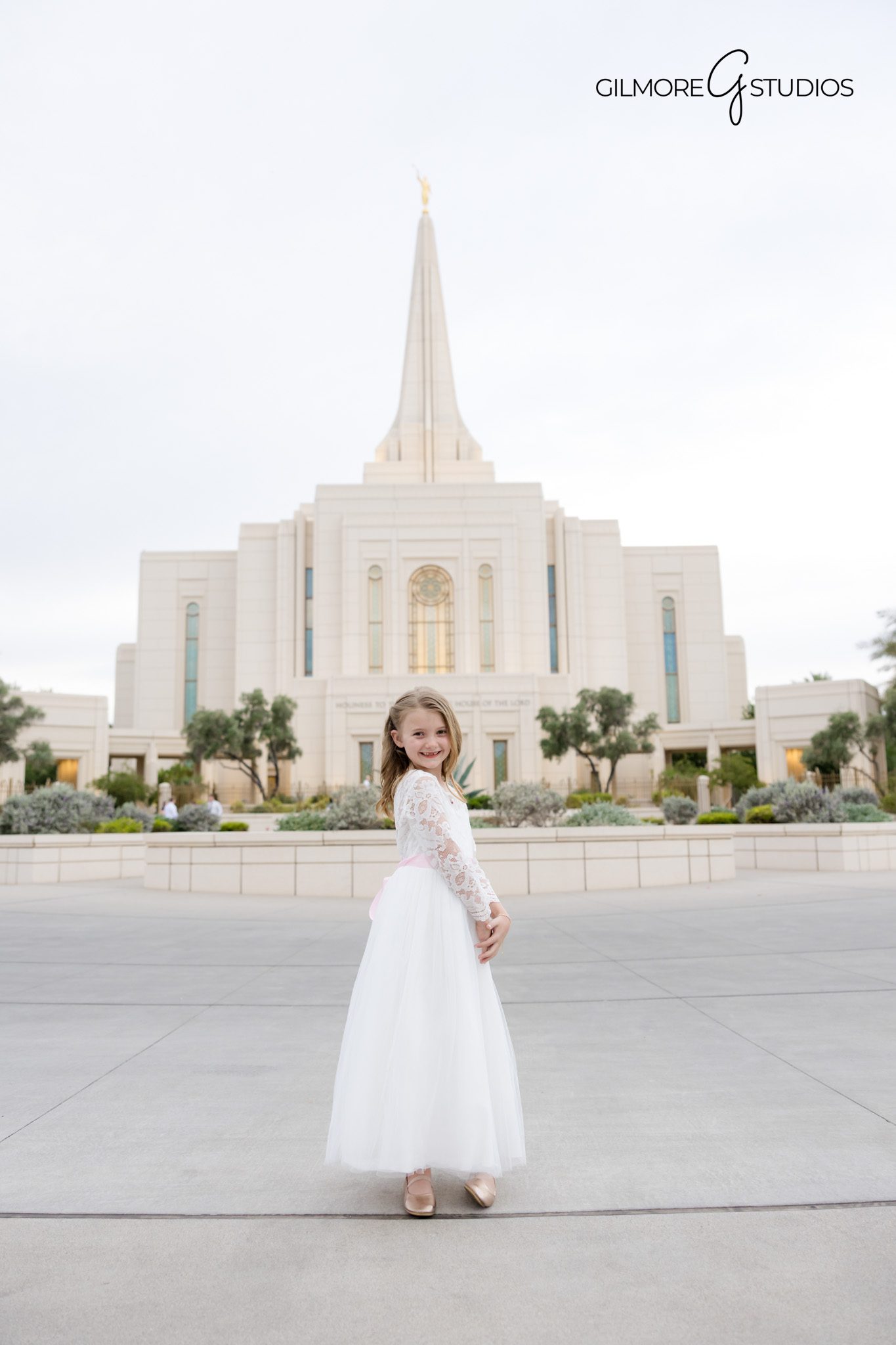 LDS baptism session at Gilbert Arizona Temple with sunset lighting
Gilbert Arizona baptism photography with child hugging Book of Mormon