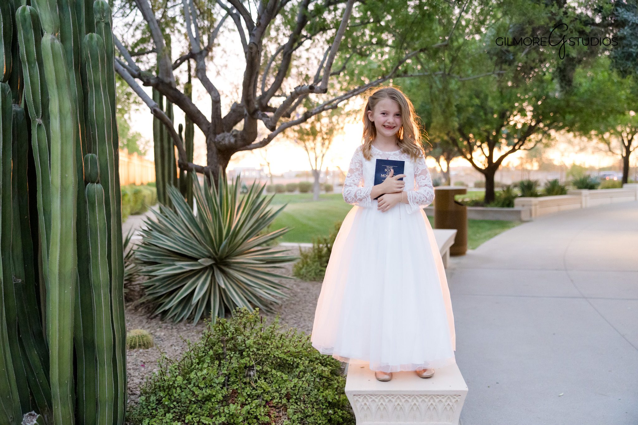 Child baptism portraits at Gilbert Arizona Temple with Book of Mormon
Gilbert temple baptism photography session with smiling young girl