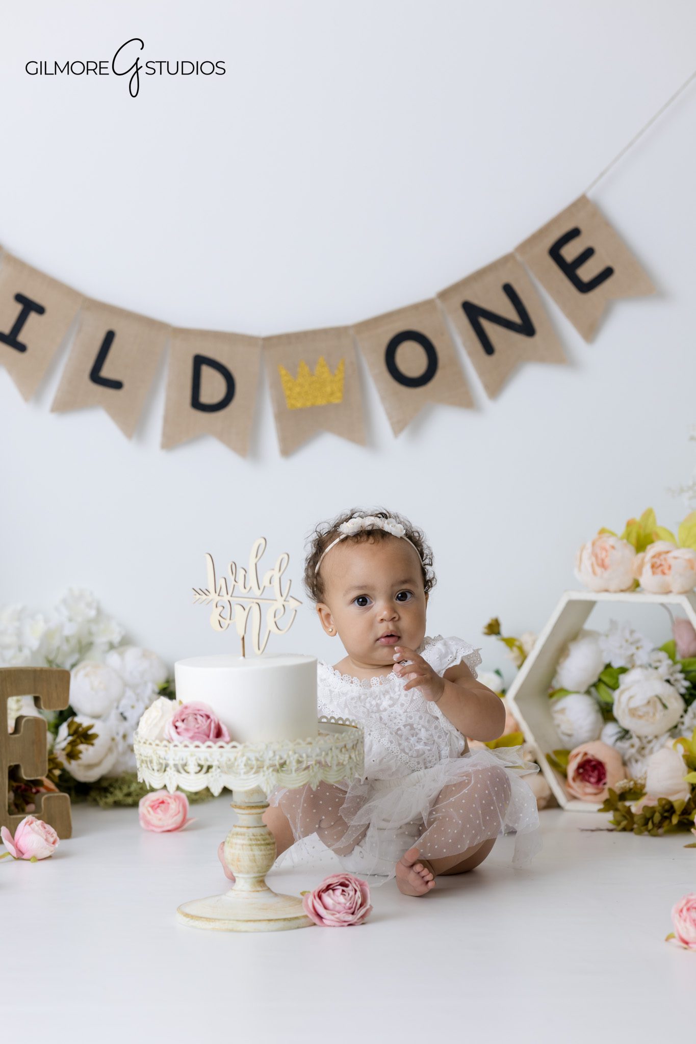 First birthday cake smash photographer Gilbert AZ with neutral floral studio setup for baby girls