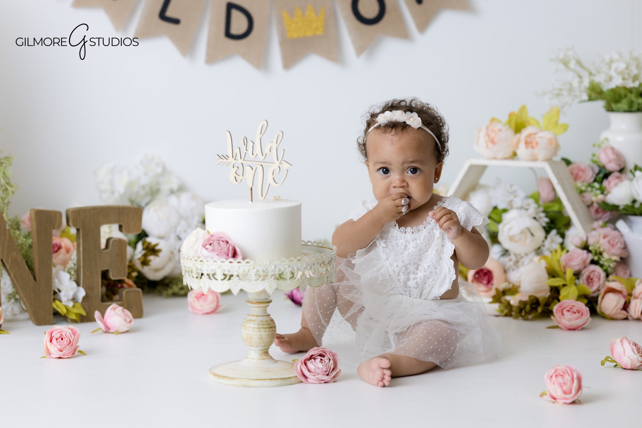 First birthday photography Gilbert Arizona with floral theme and white birthday cake