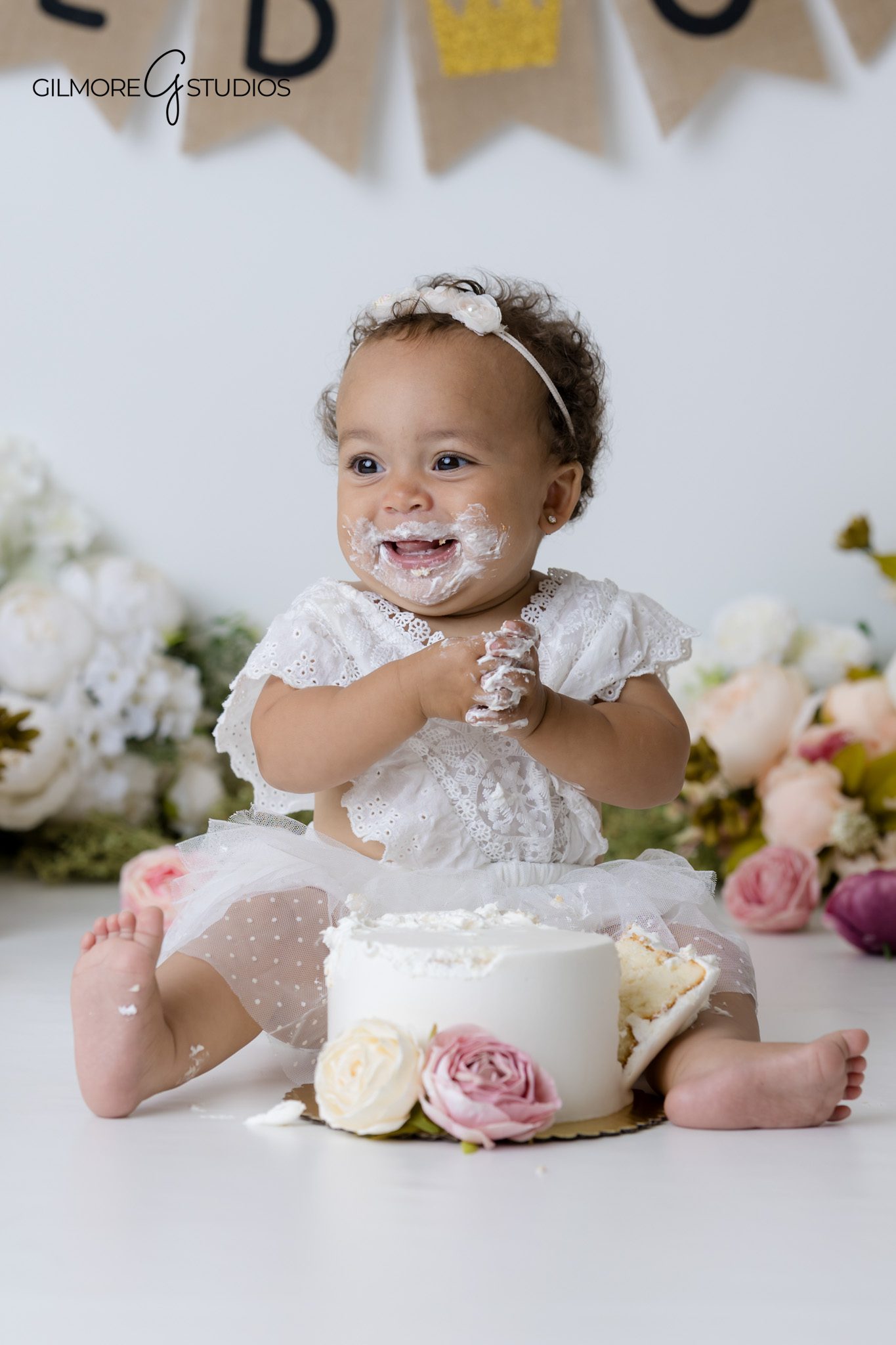 Luxury cake smash photography Gilbert AZ featuring baby girl in white dress and flower setup
Gilbert Arizona baby photographer with floral themed cake smash session for first birthday portraits