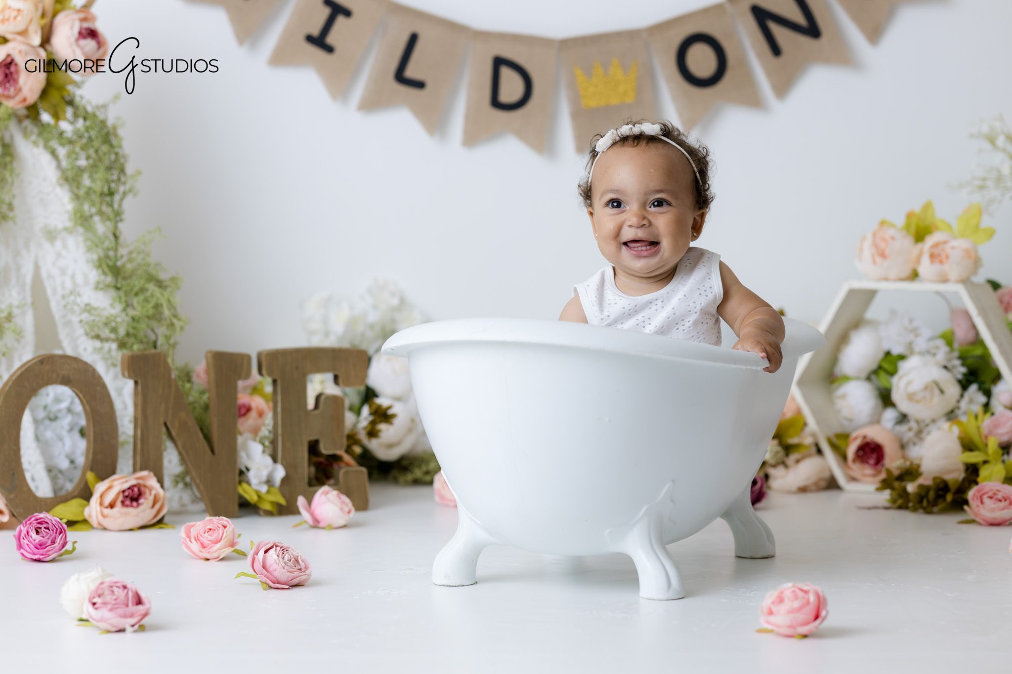 Floral themed first birthday cake smash session in Gilbert Arizona with neutral white backdrop