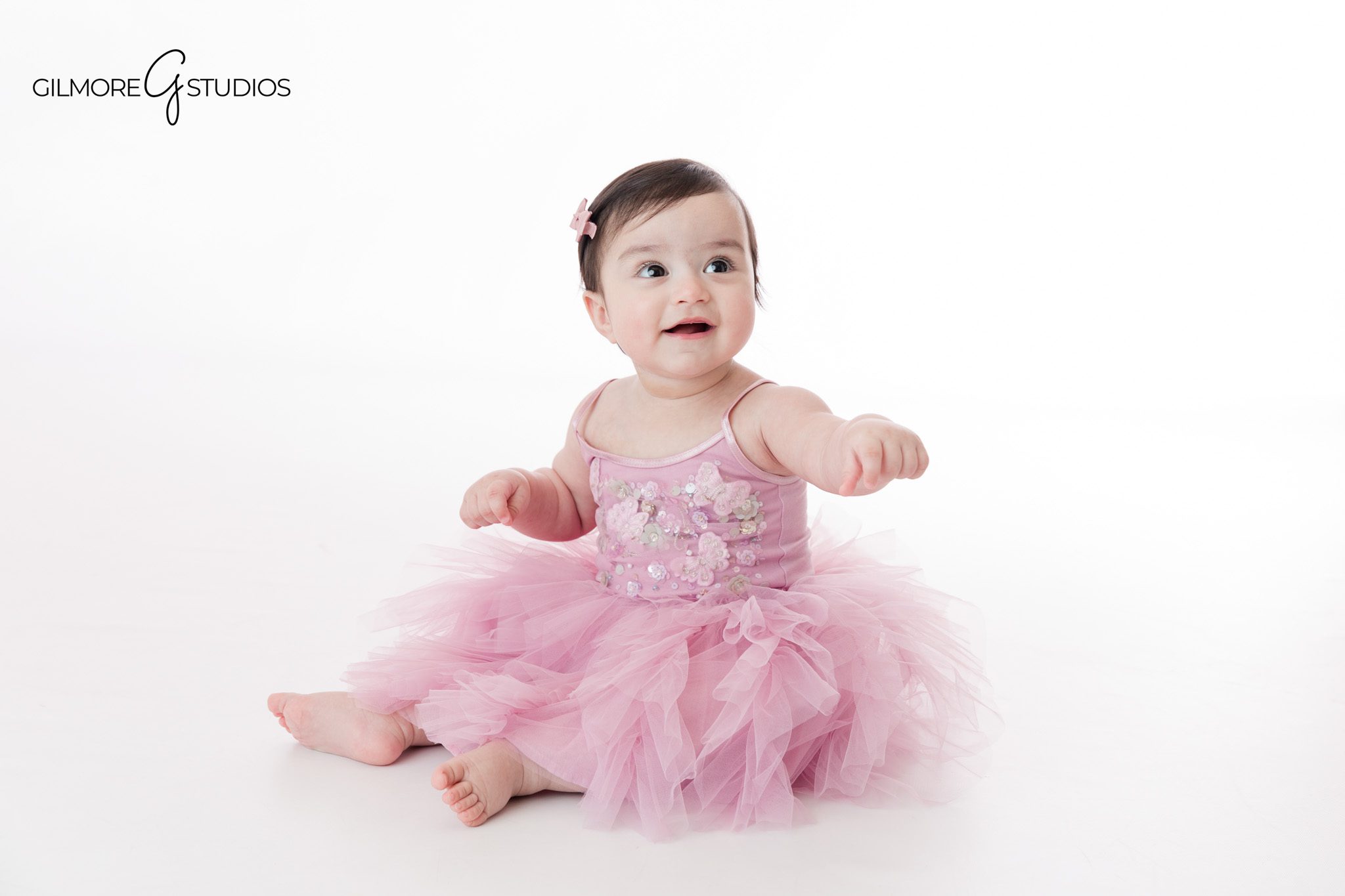 Newport Beach sitter session with baby smiling in a spring setup
Six month baby milestone photos photographed at Gilmore Studios