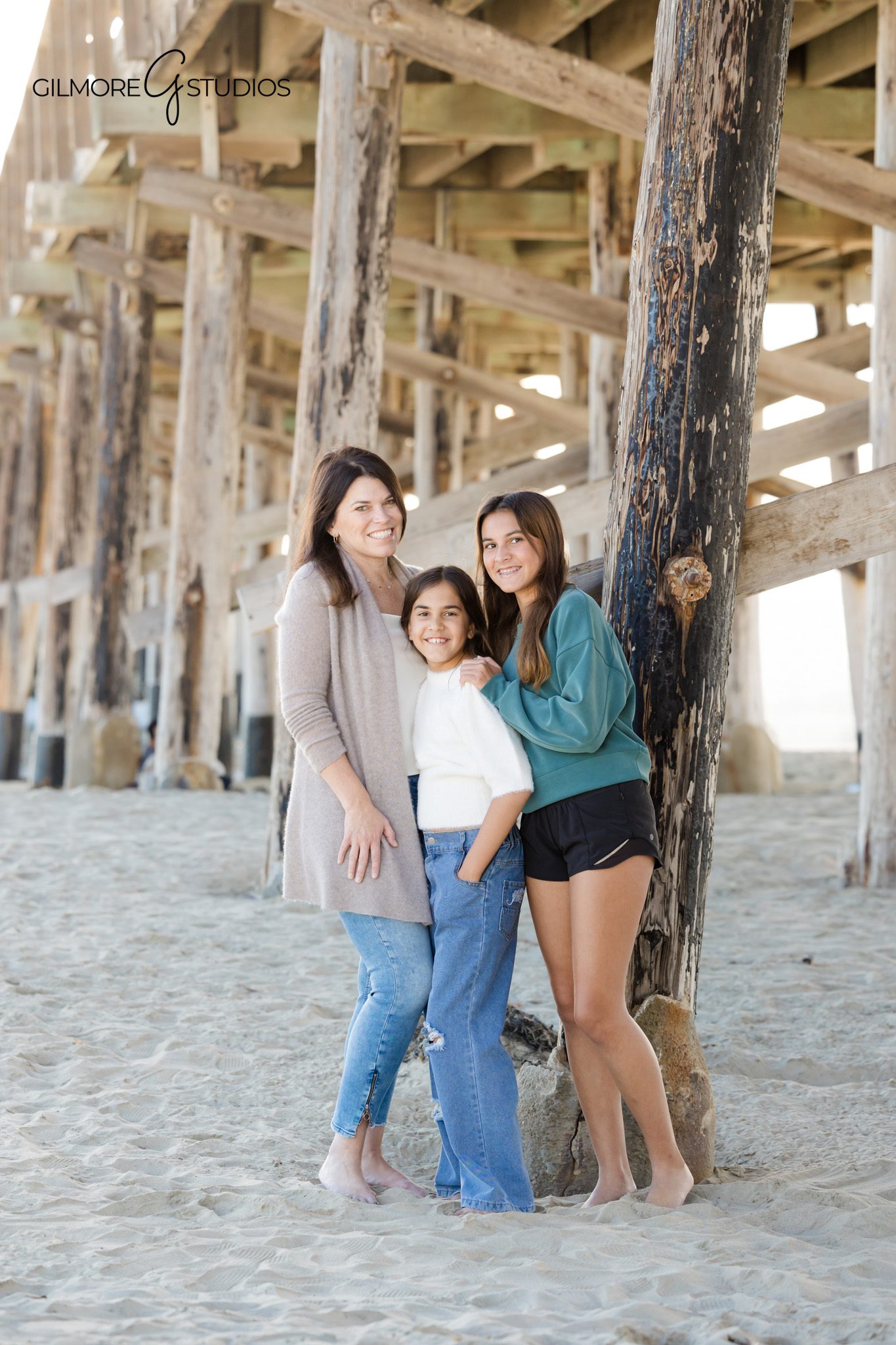 Newport Pier family photography session with ocean and pier in the background
Family smiling together on the beach during a November Newport Pier session