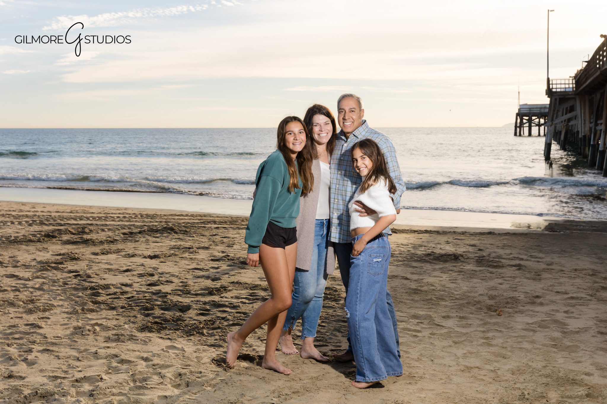 Newport Pier family session with soft sand and ocean views
Family standing near the water during golden hour at Newport Pier