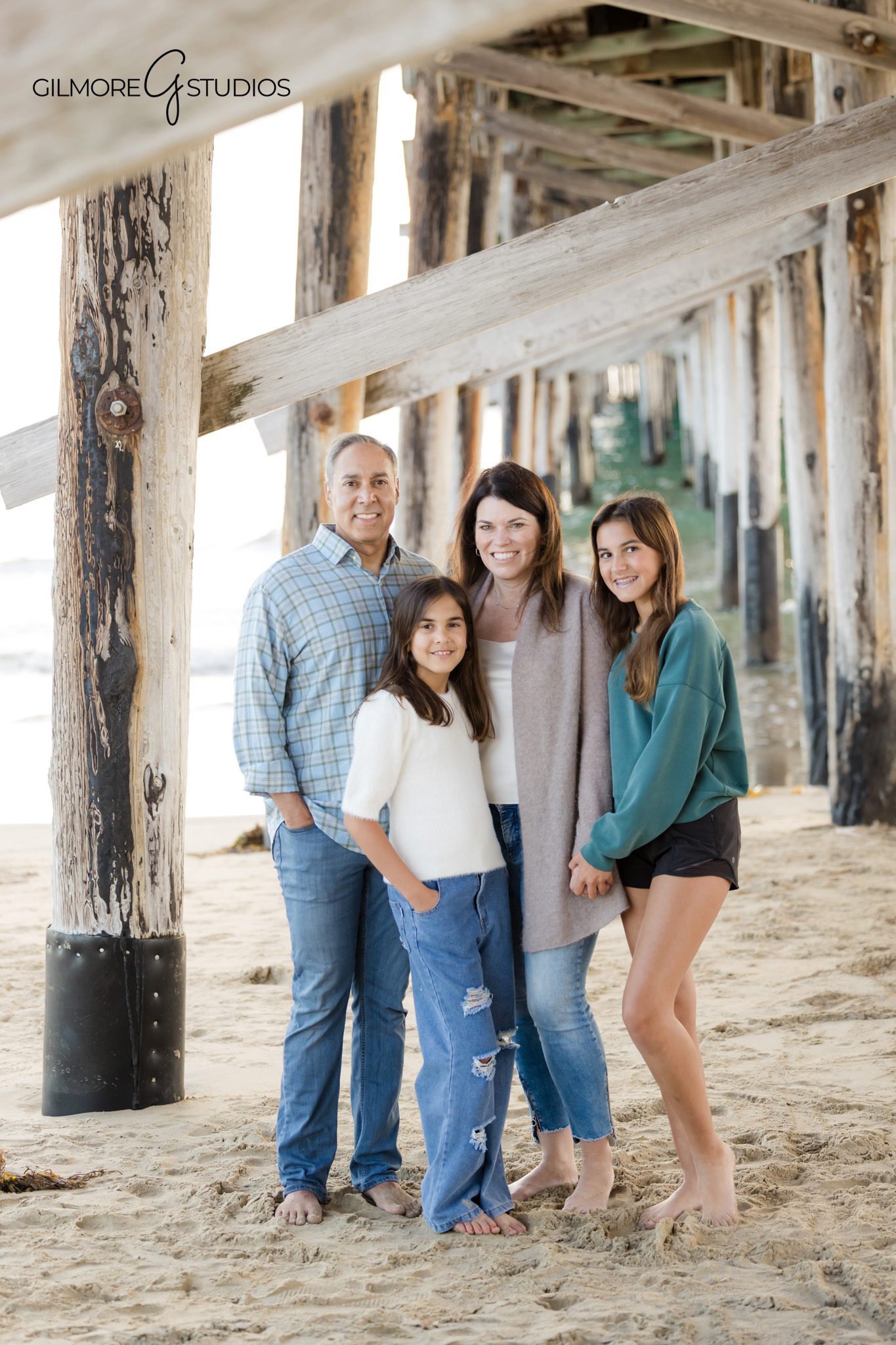 Family walking along the Newport Beach shoreline during a fall session
Newport Pier family photographer photographing natural beach portraits