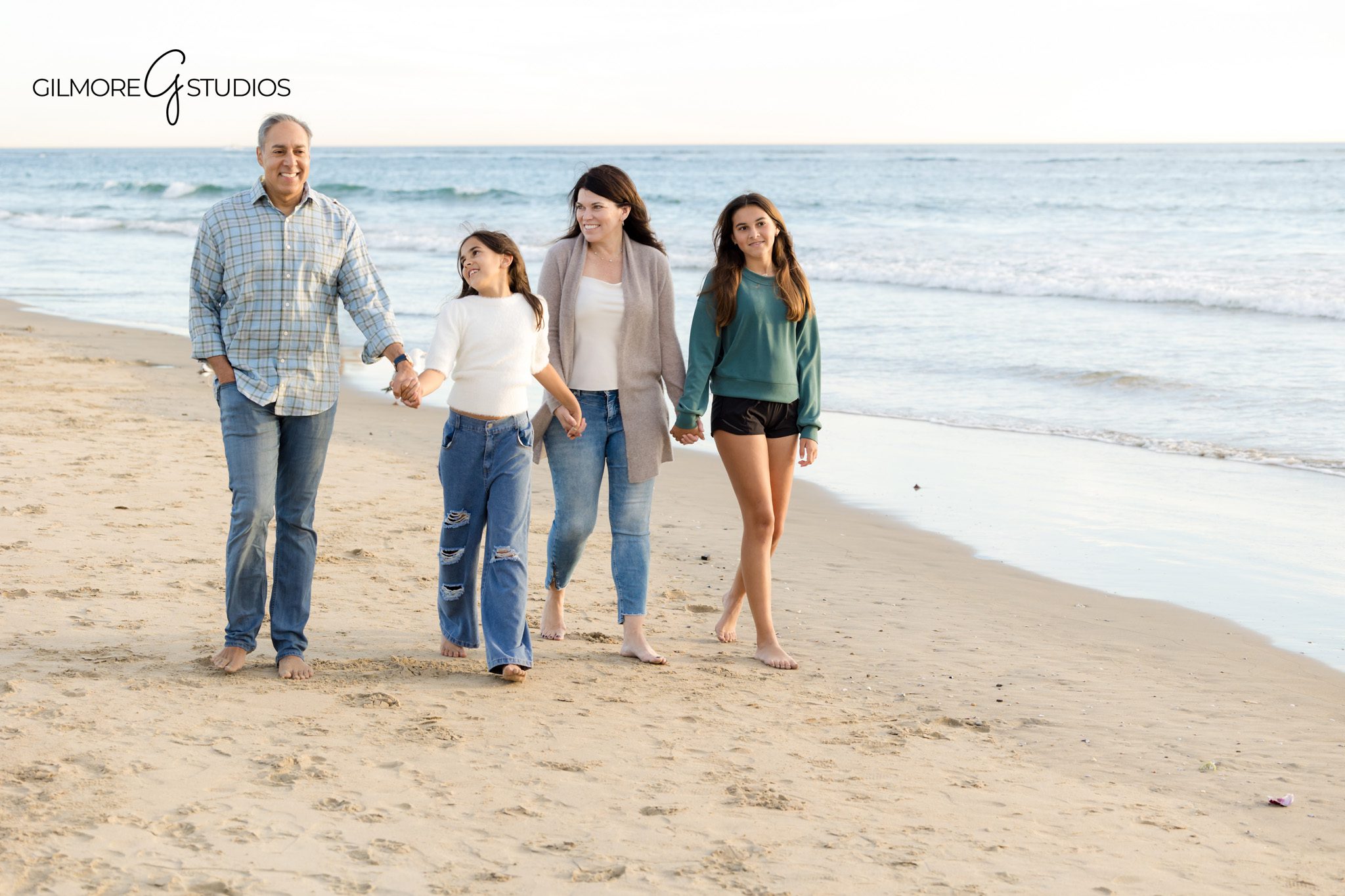 Parents walking with children near Newport Pier at golden hour
Orange County beach family photography session at Newport Pier