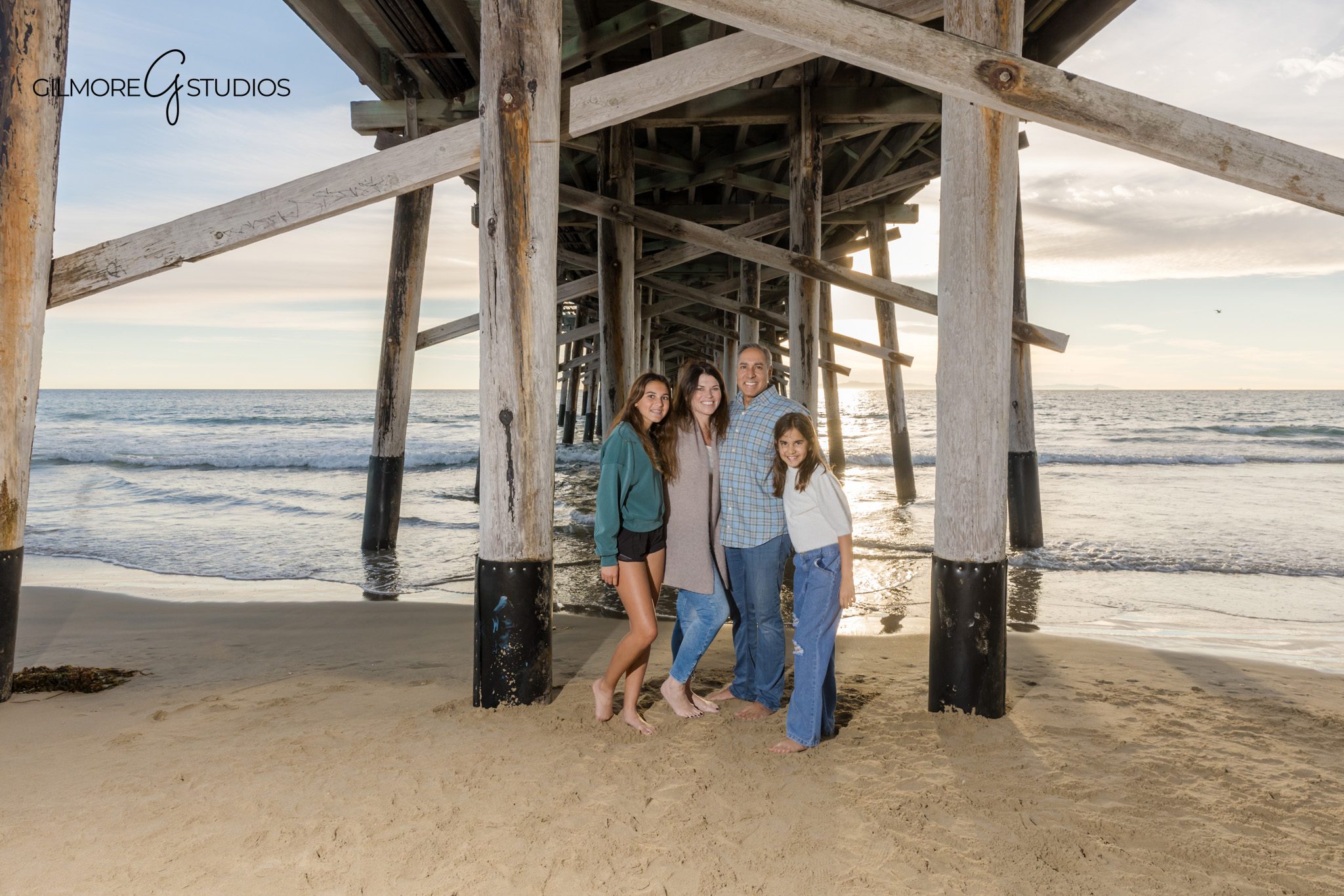 Parents walking with children near Newport Pier at golden hour
Orange County beach family photography session at Newport Pier