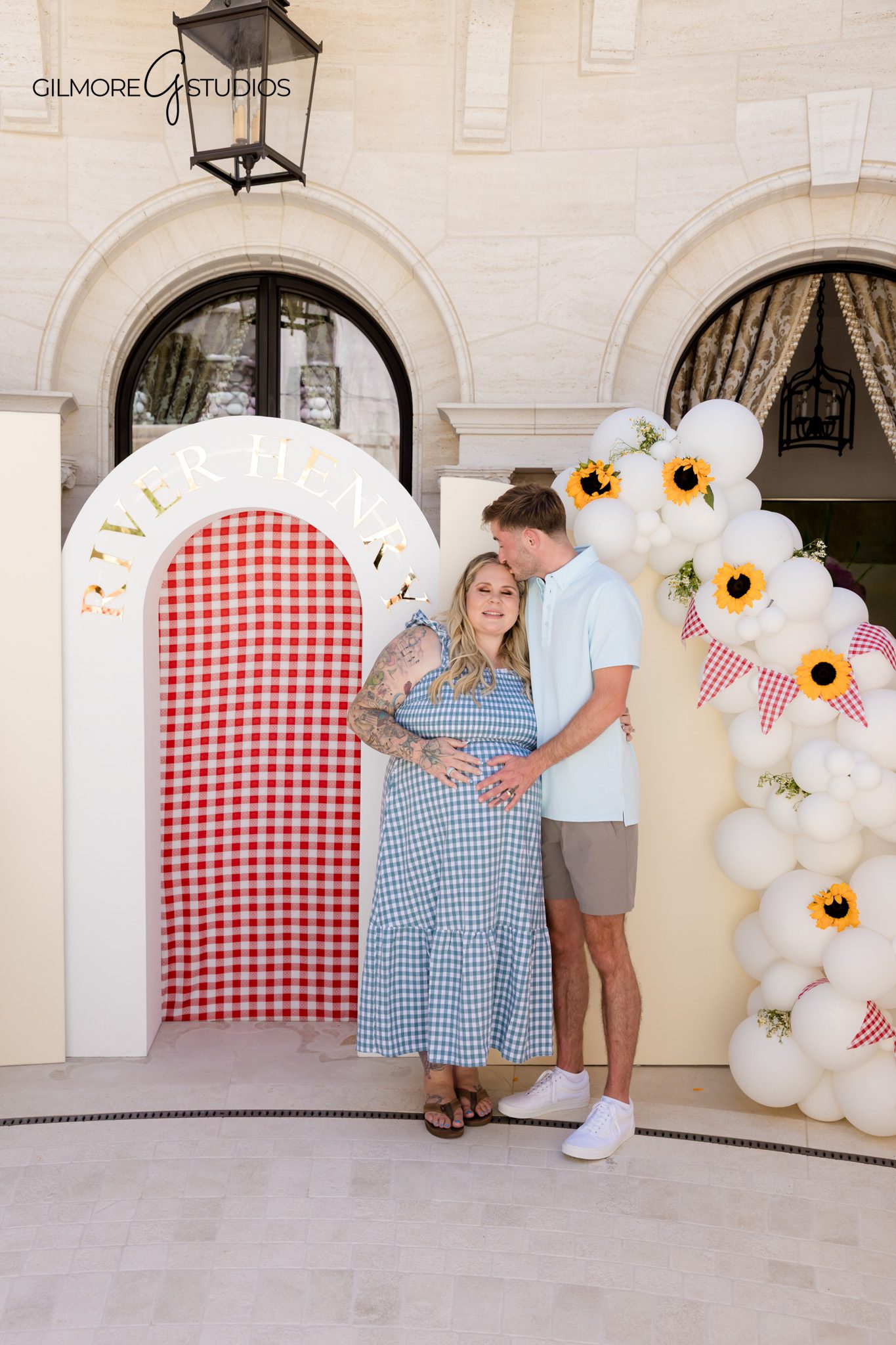 Mom-to-be holding baby bump during Newport Beach baby shower portraits
Baby shower celebration at a private estate with outdoor tables and signage