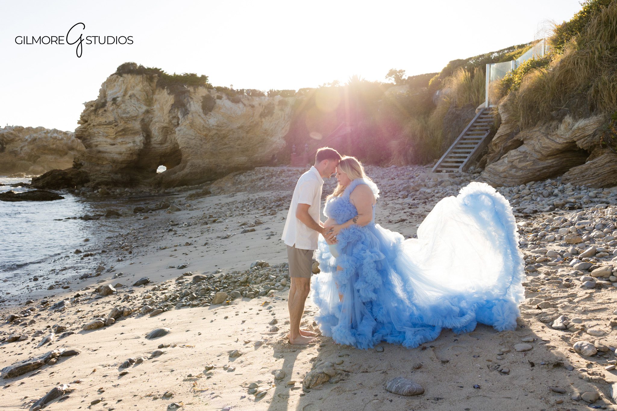 Mother-to-be holding her belly during a private beach maternity session
Orange County maternity portraits with beach, cliffs, and golden light