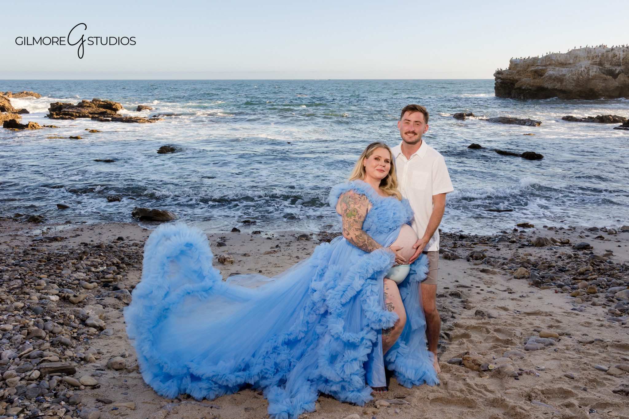 Mom-to-be in a white dress photographed on the beach in Corona del Mar
Newport Beach maternity portraits with sand, ocean, and golden hour light