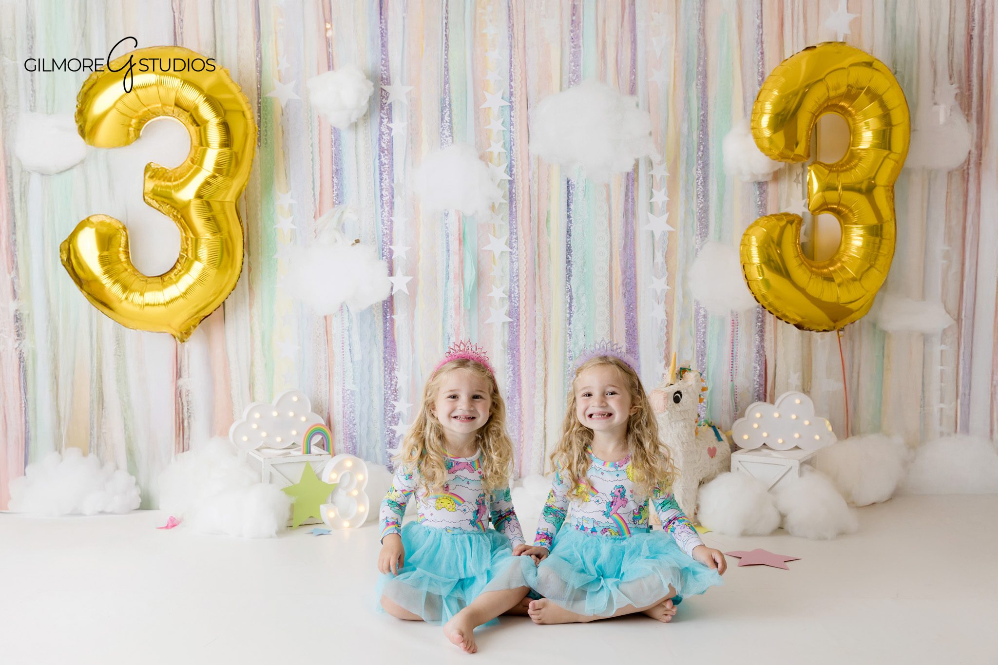 Newport Beach studio birthday session with unicorn theme for twins
Twin girls smiling in front of pastel balloons during birthday portraits