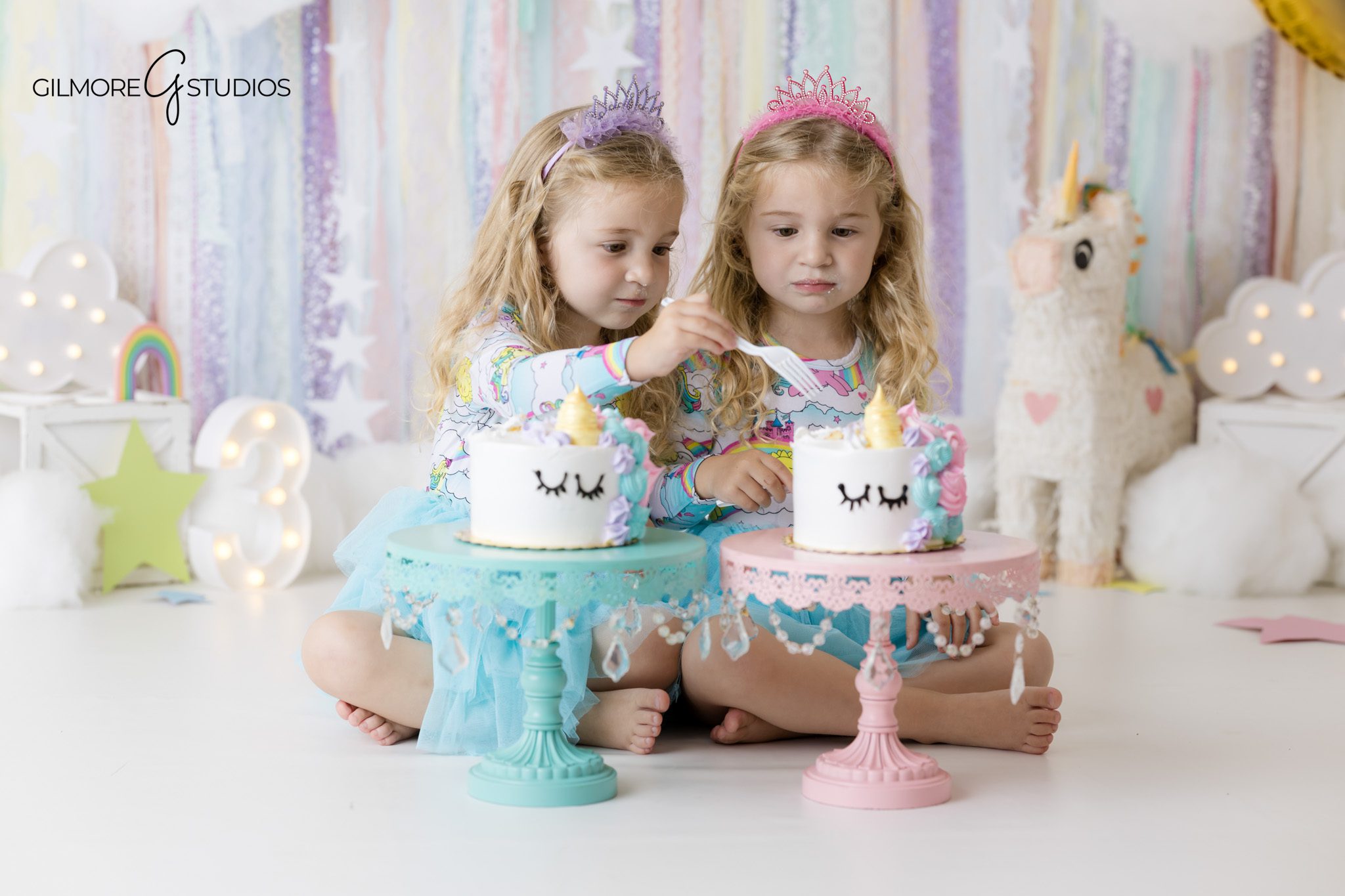 Unicorn birthday photos with twin girls and soft pastel studio decor
Twin cake smash photographer capturing individual cakes for twin sisters