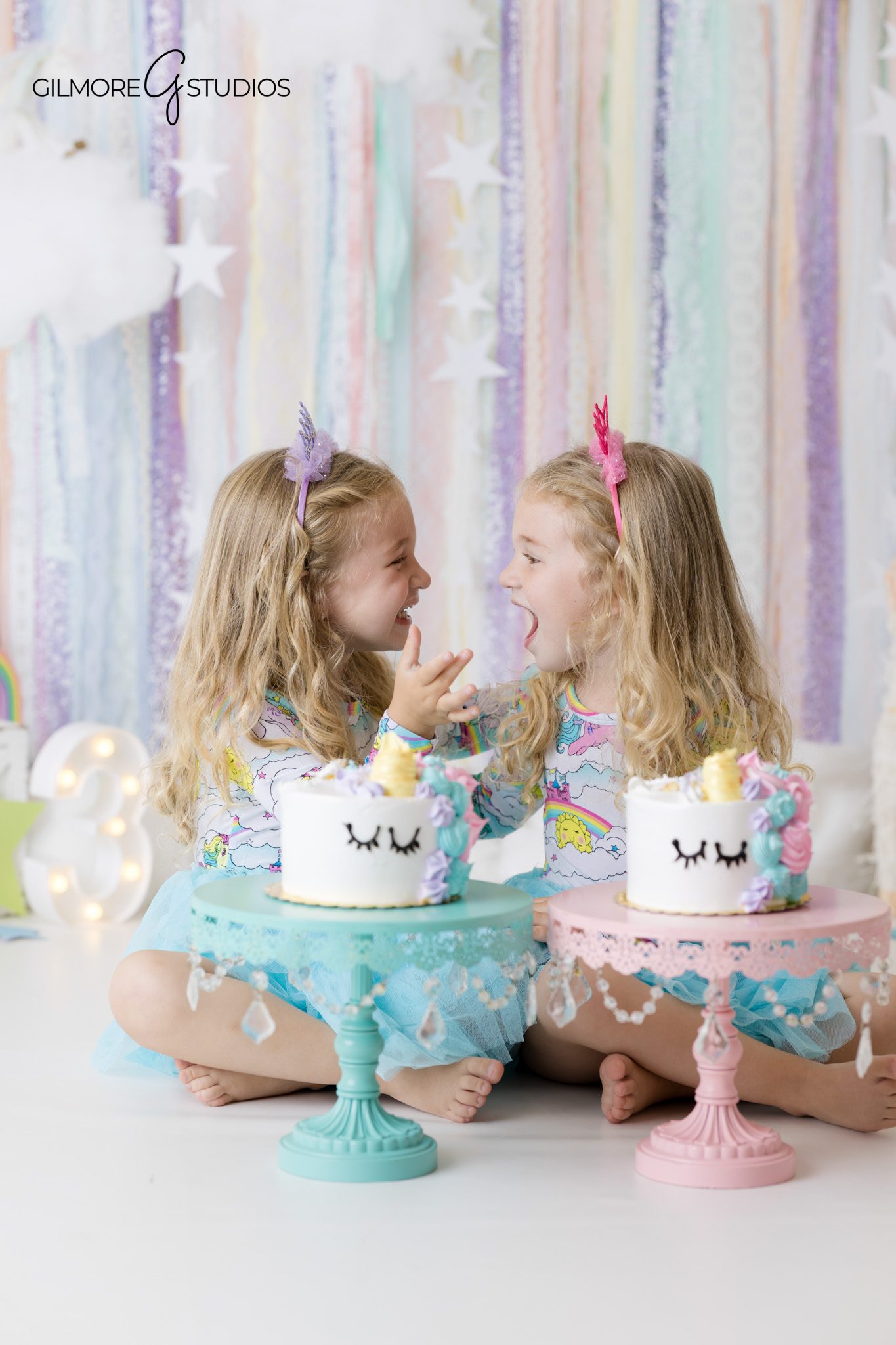 Newport Beach cake smash photographer photographing twin girls with unicorn cakes
Twin girls wearing pastel dresses during a unicorn birthday portrait session