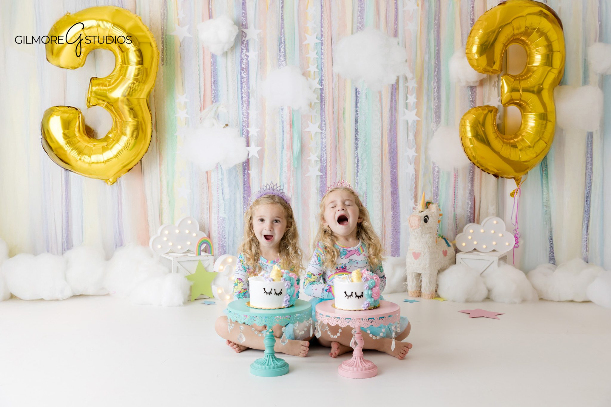 Newport Beach toddler birthday photographer capturing twins in studio
Twin cake smash photos with frosting and pastel unicorn decorations