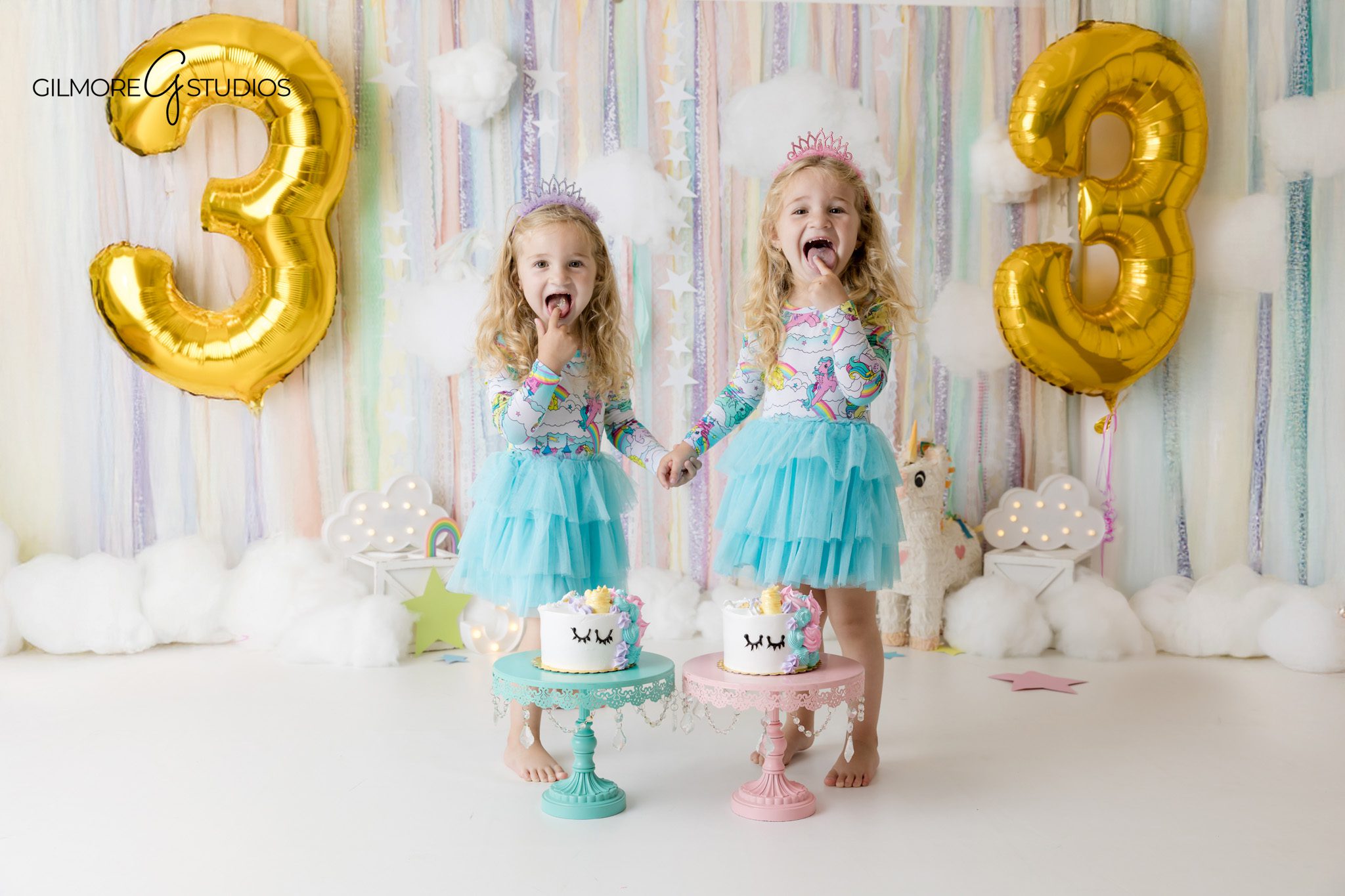 Twin girls exploring their cakes during a unicorn cake smash session
Orange County cake smash photographer capturing twin birthday photos