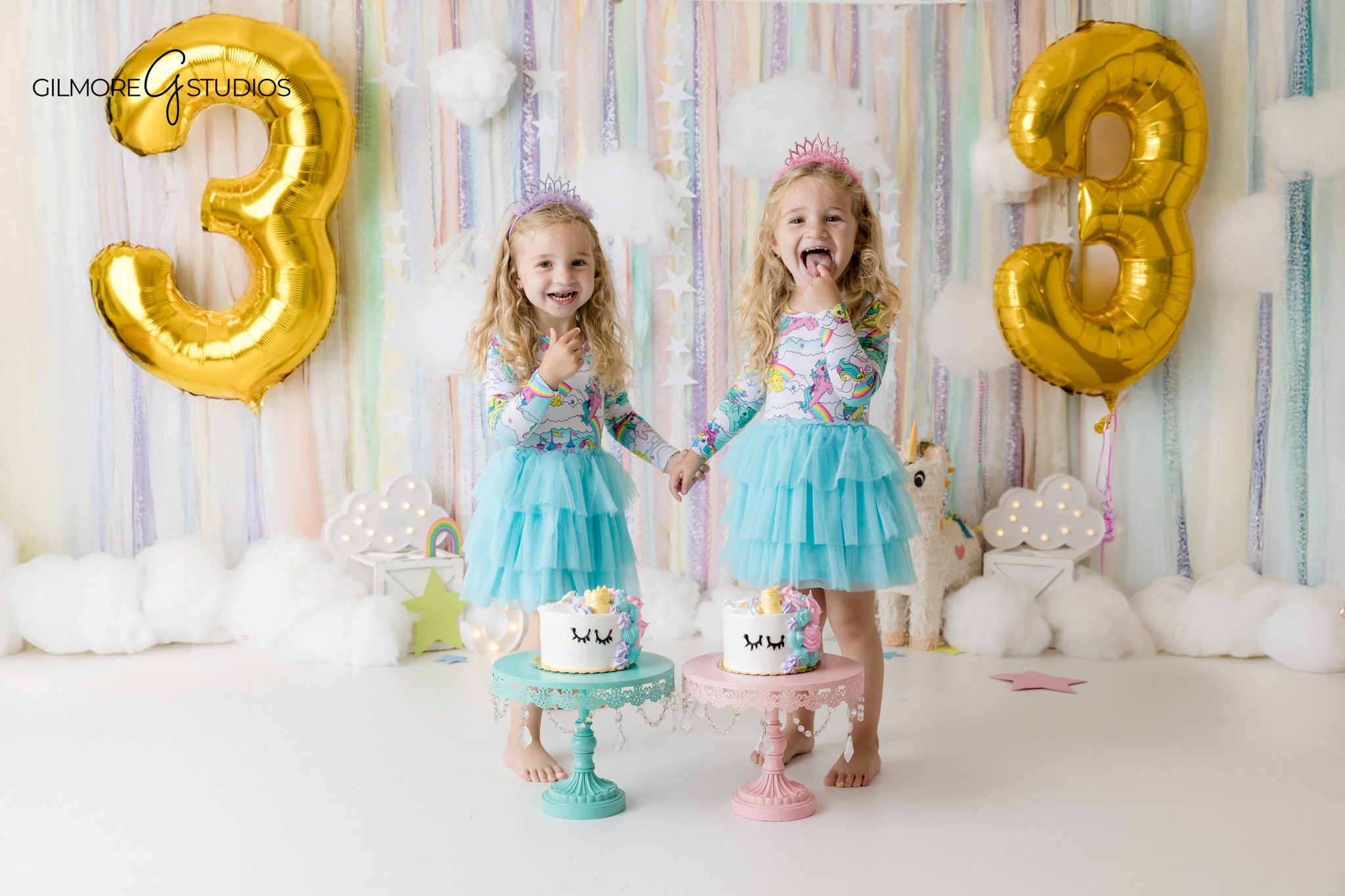 Twin girls smiling together during a pastel unicorn cake smash session
Newport Beach studio portraits for twin girls birthday celebration