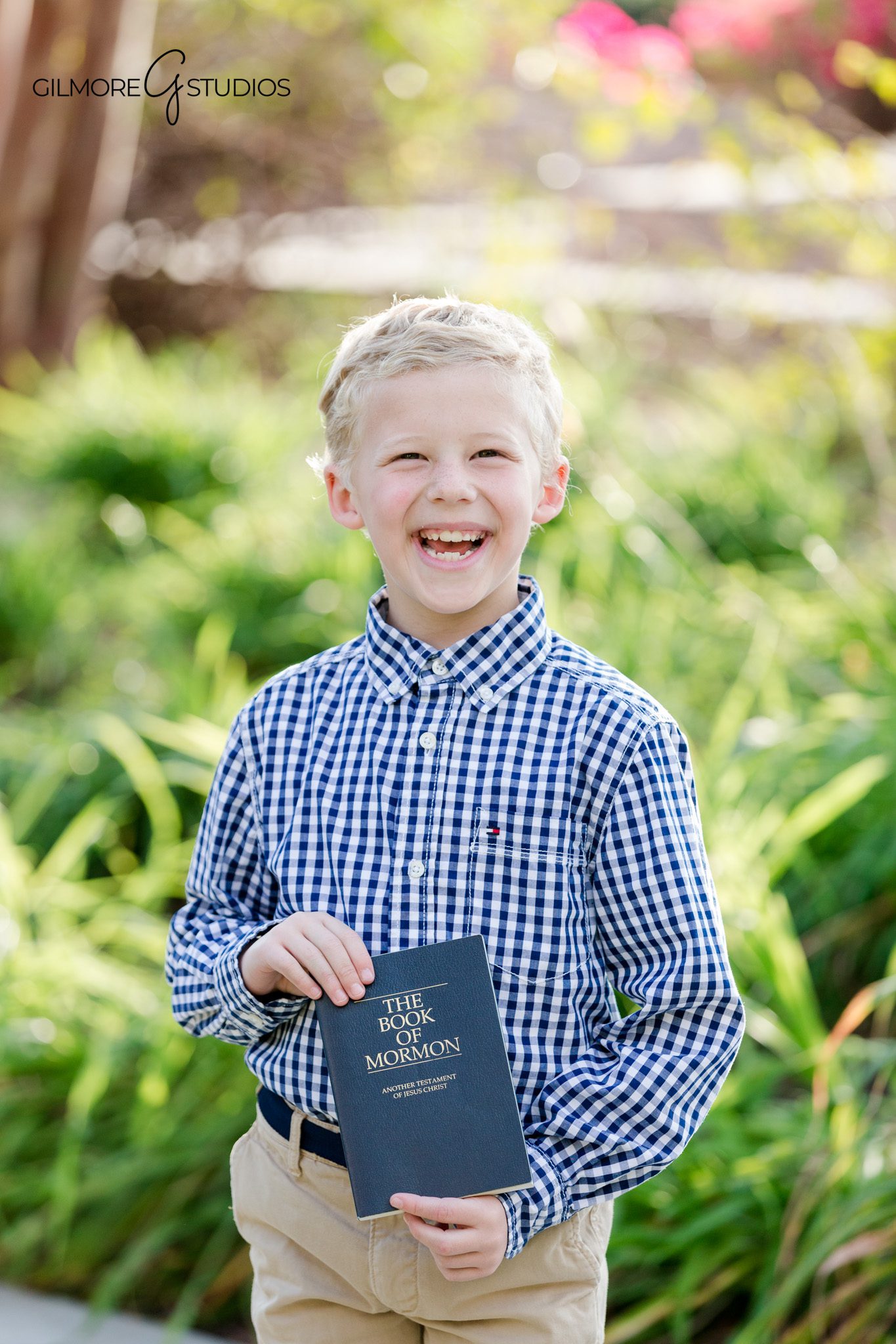 Boy in church clothes holding Book of Mormon for baptism photos
LDS baptism portraits with temple gardens and colorful flowers