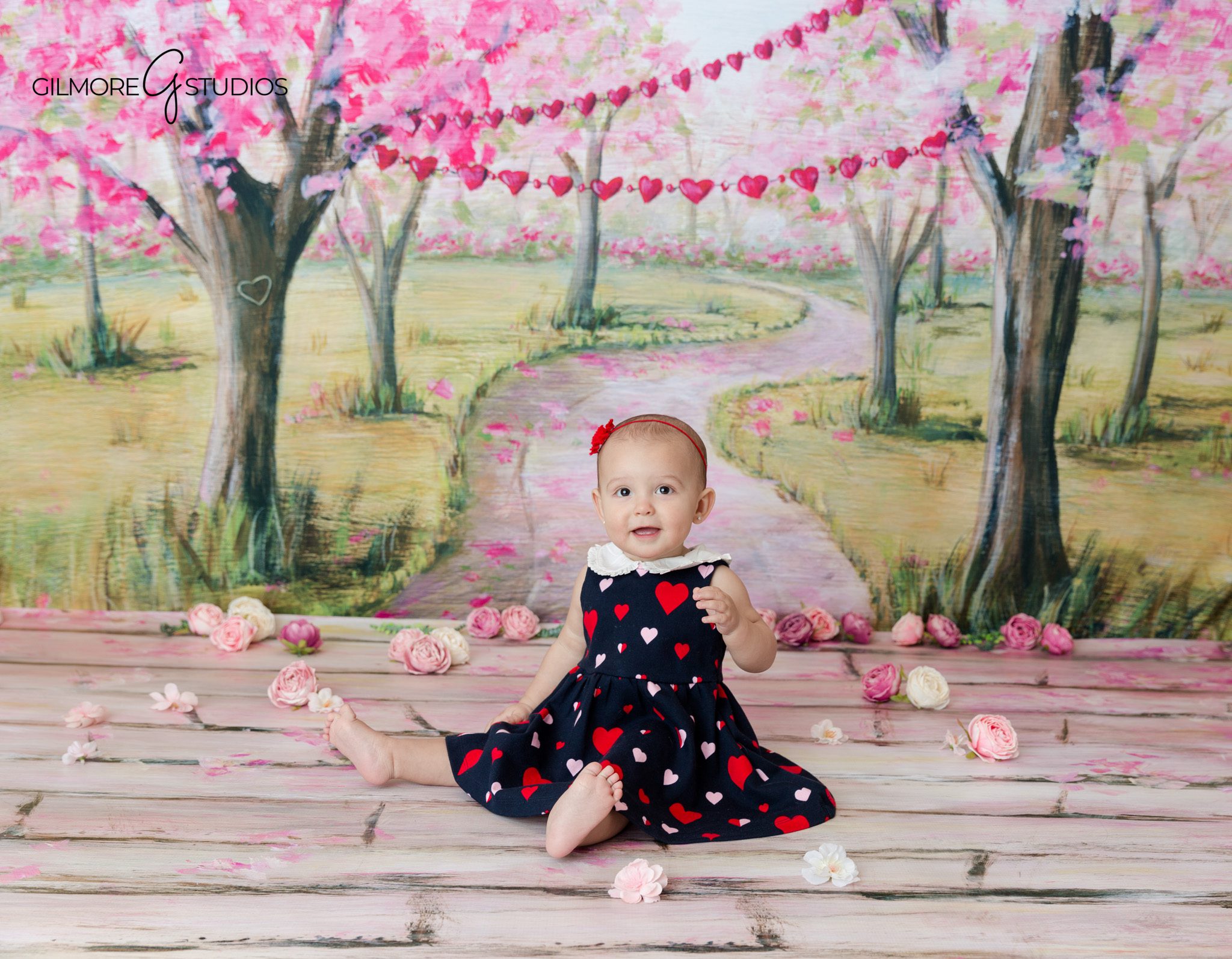 Baby reaching for flowers during sitter session at Gilmore Studios
Family milestone session with baby sitting confidently on neutral backdrop