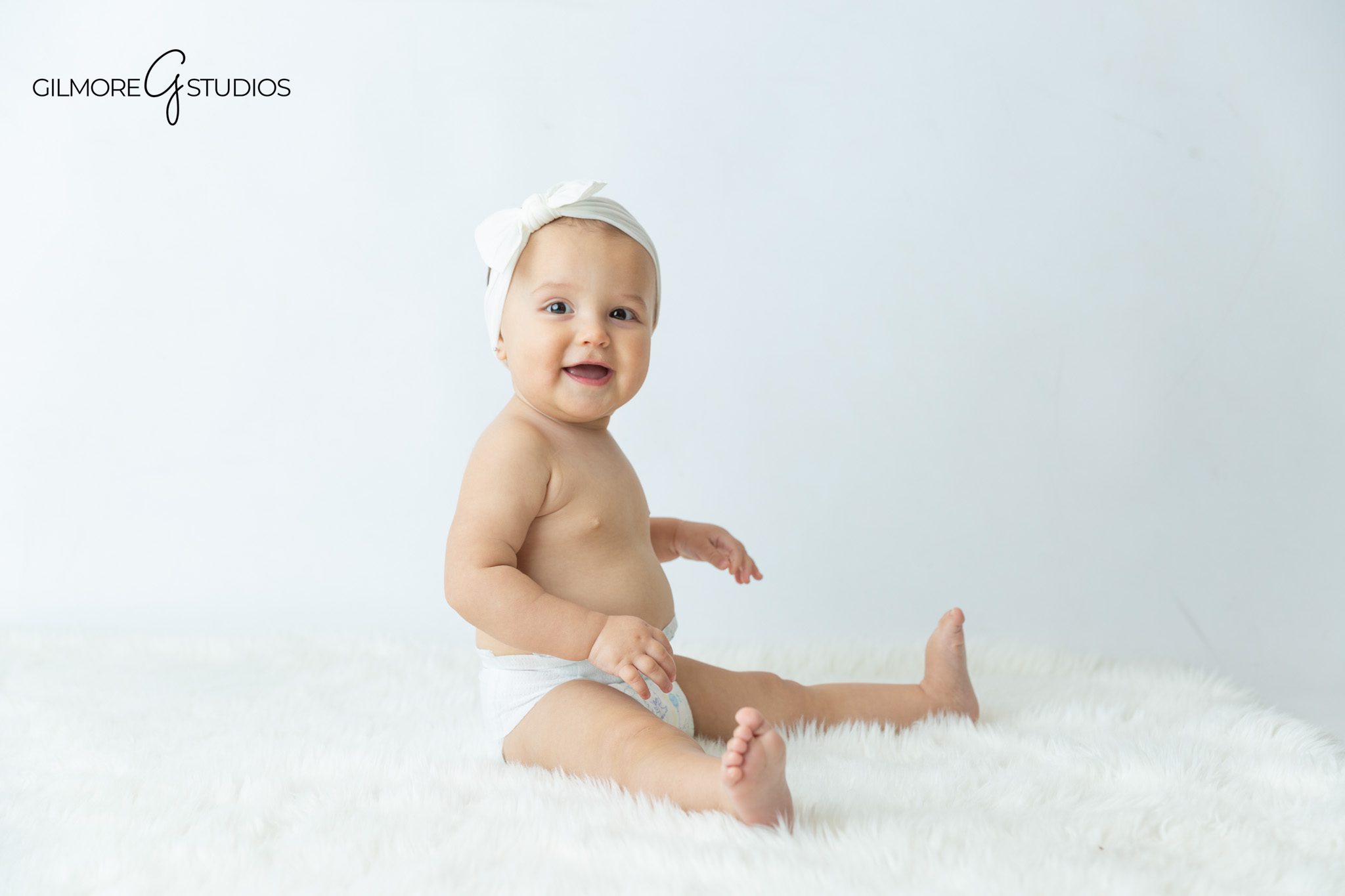 Newport Beach studio baby portraits with parents and sitting up milestone photos
Sitting up baby photos with soft florals and simple studio styling