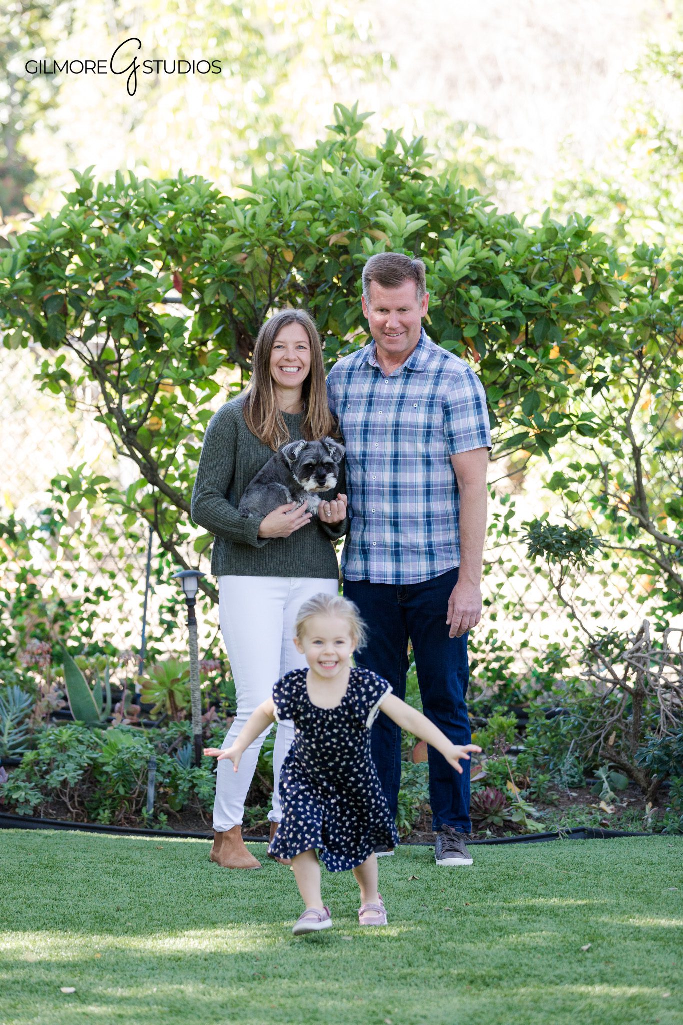 Backyard family portraits with greenery, flowers, and warm evening light
Orange County family photographer capturing at-home backyard photos