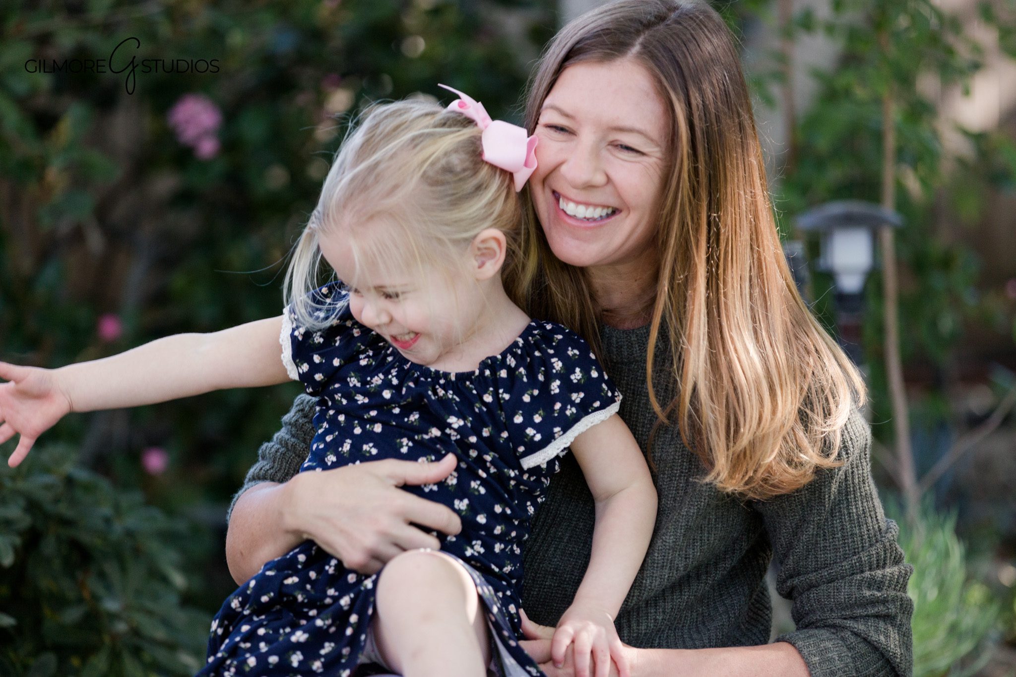 Parents hugging children in a backyard garden during family photos
At-home family session with kids playing near flowers and greenery